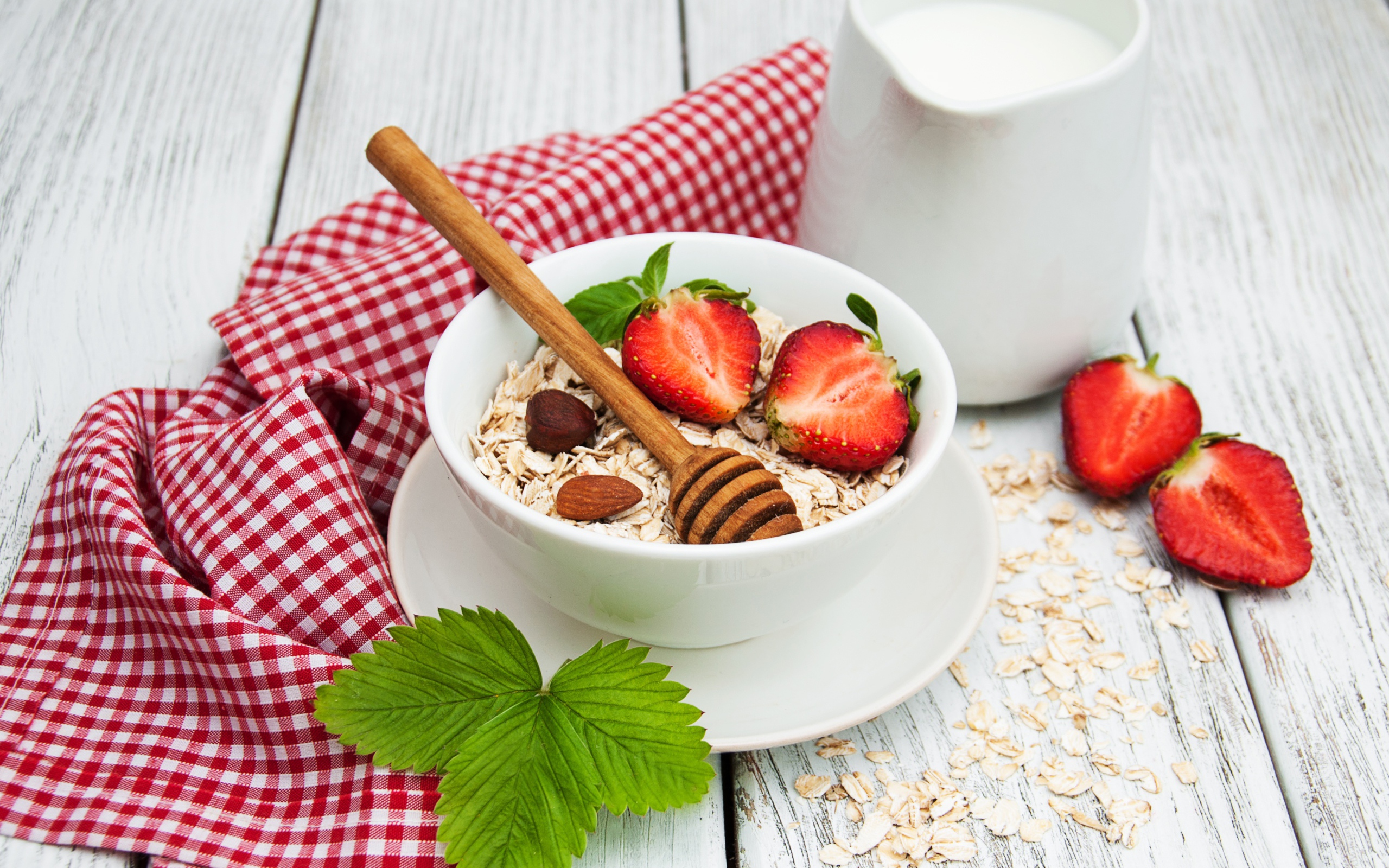 Овсяная каша на столе с молоком и клубникой