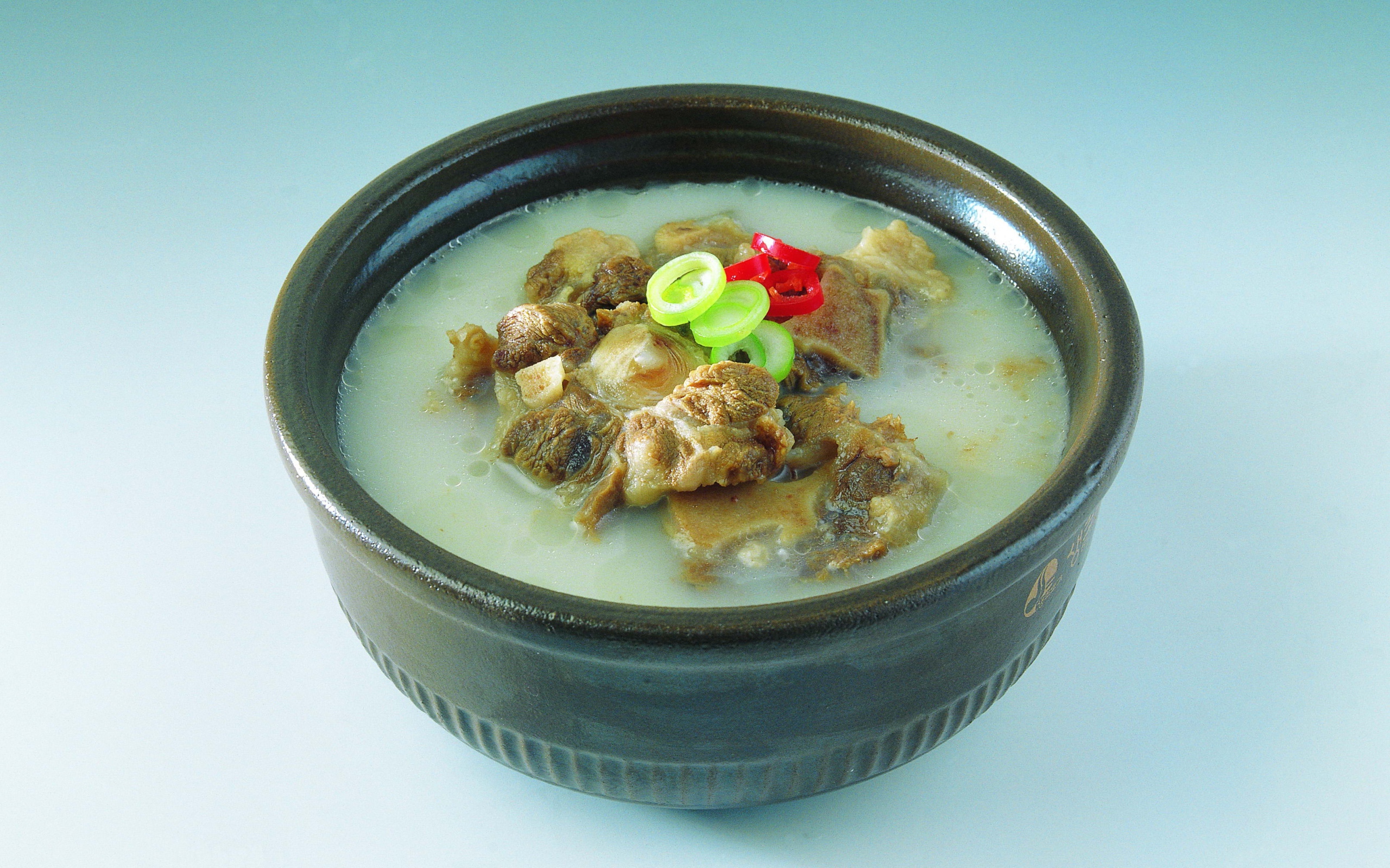 Тарелка супа с говядиной  на голубом фоне