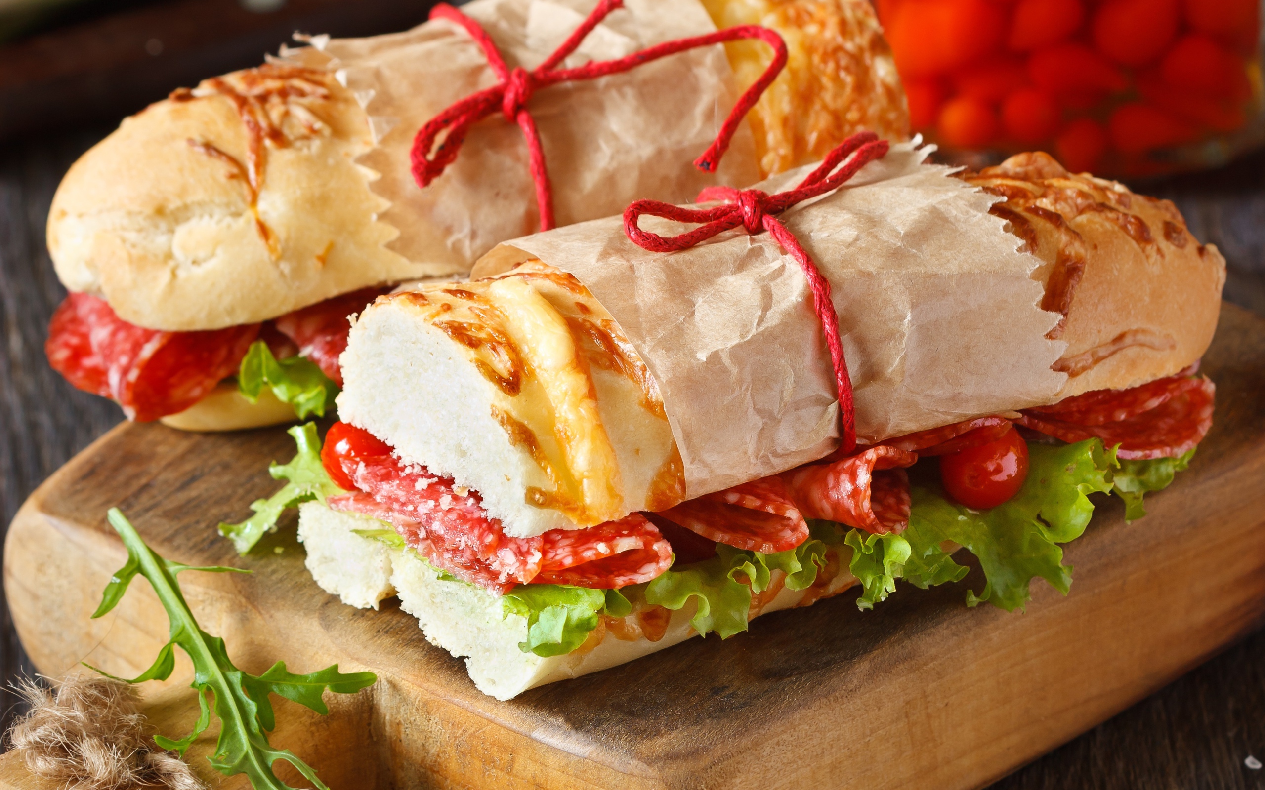 Два огромных бутерброда с колбасой и листьями салата