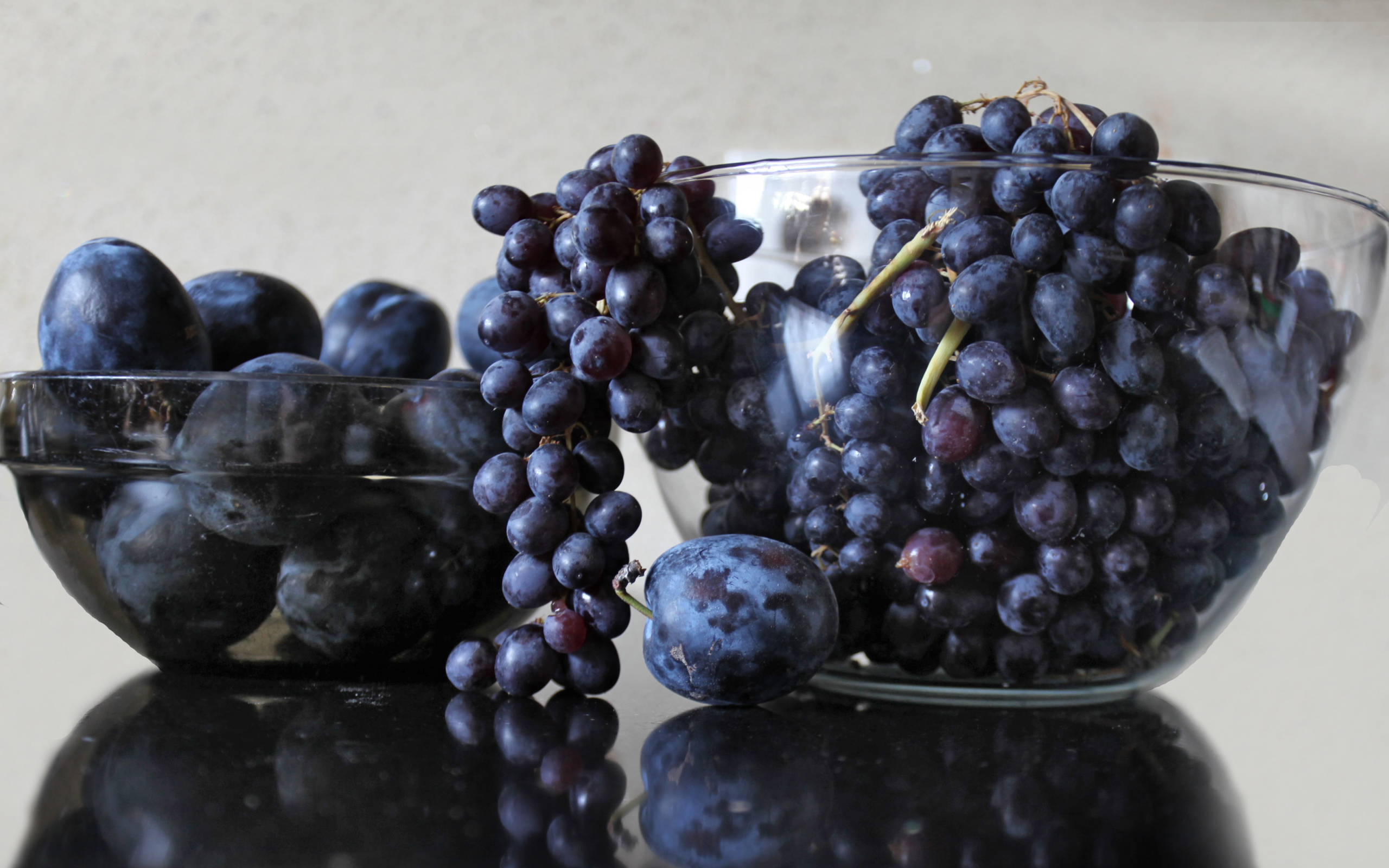 Синий виноград с синими сливами на столе