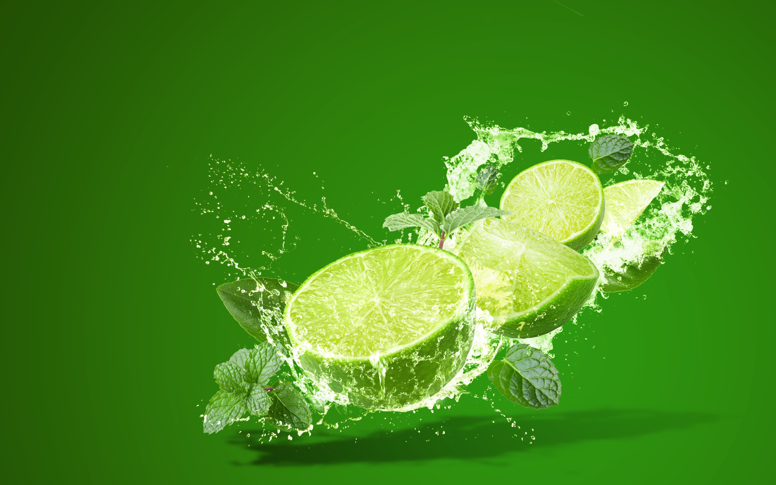 Лайм с мятой в брызгах воды на зеленом фоне