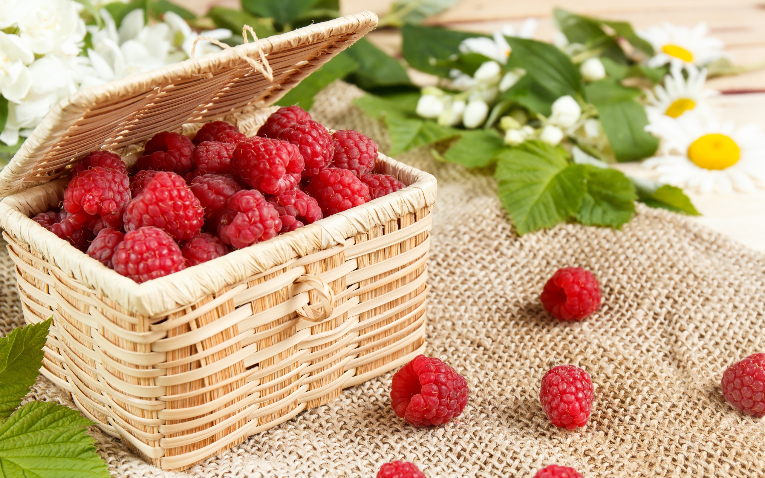 Плетеная корзина на столе с ягодами малины 
