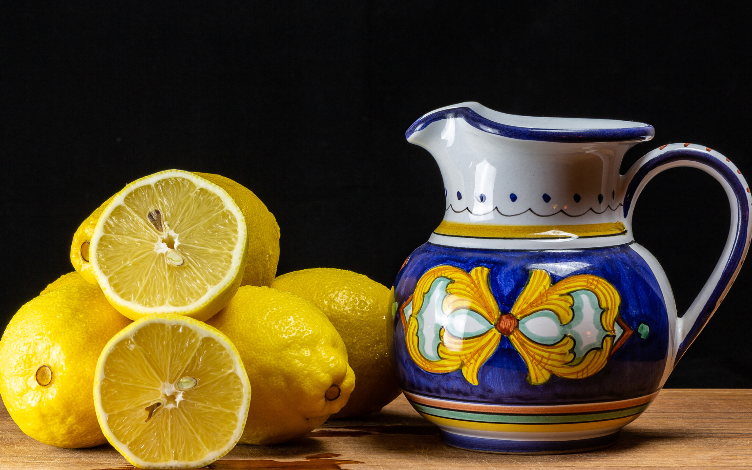 Желтые лимоны на столе с кувшином
