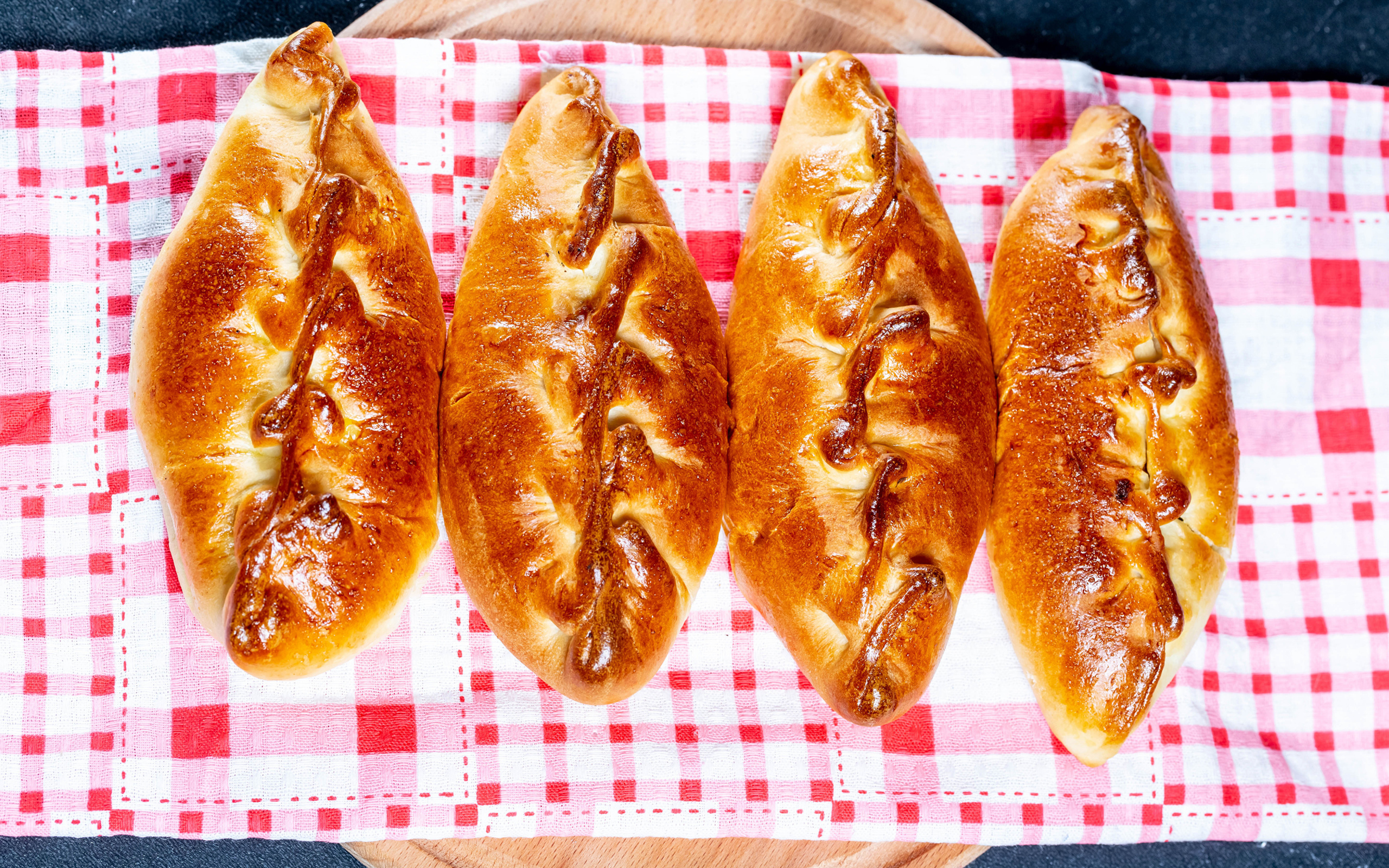 Аппетитные румяные пирожки лежат на полотенце 