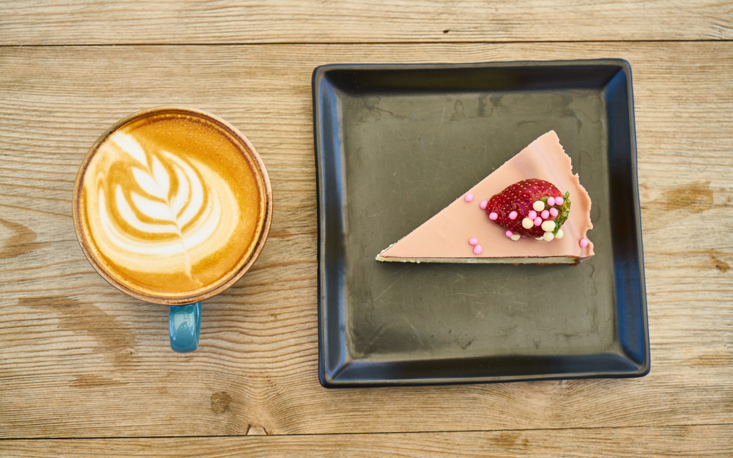 Кусок торта на черной тарелке с кофе