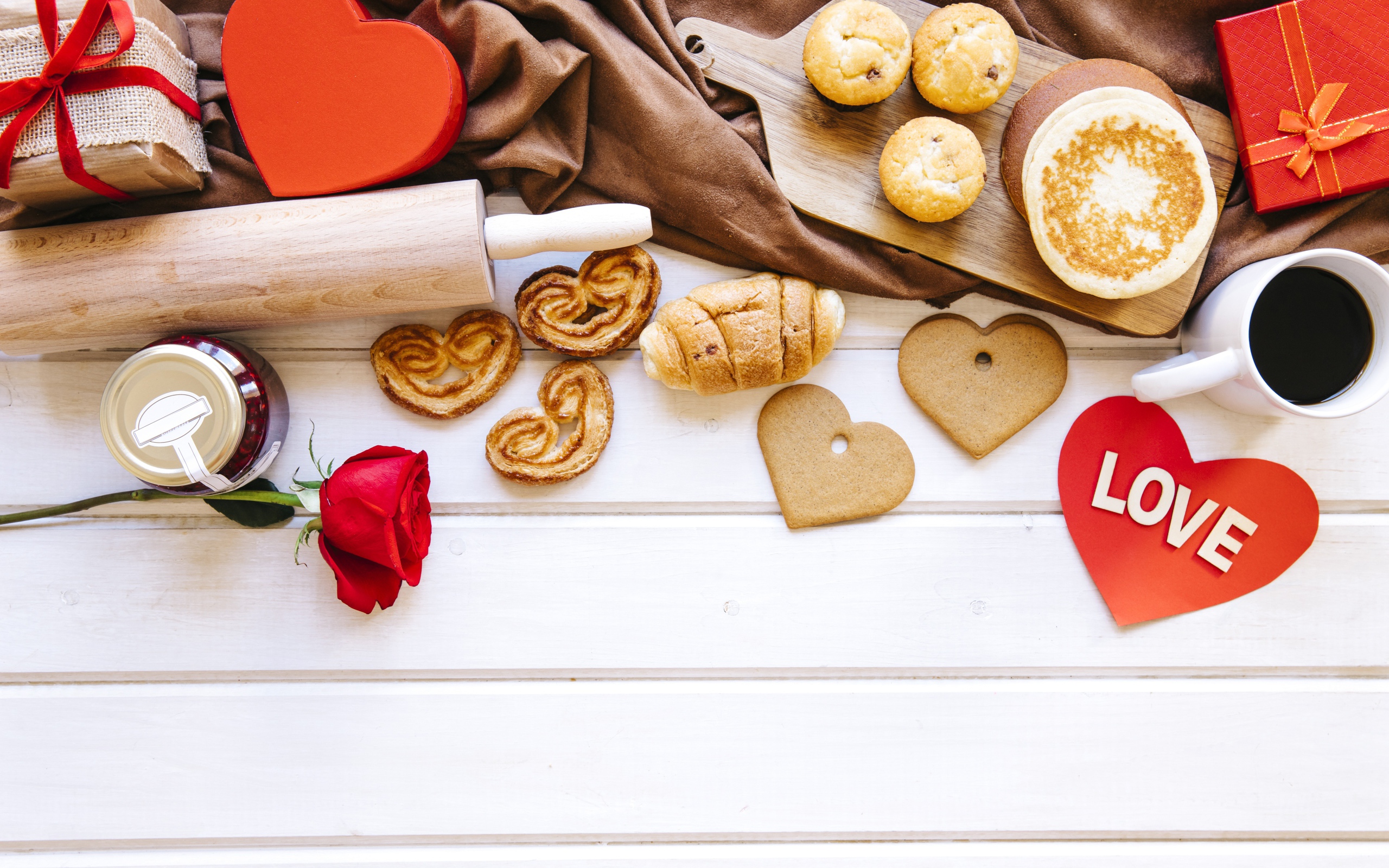 Аппетитная сладкая выпечка на столе с кофе, сердечками и подарками 