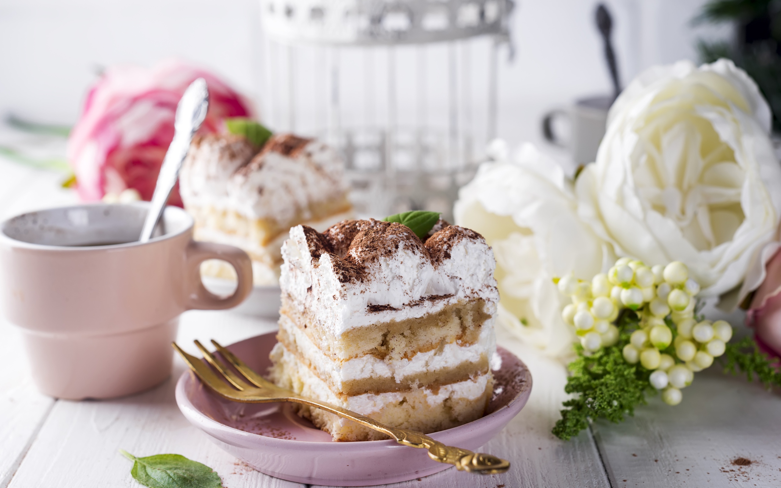 Пирожное на столе с кофе и цветами 