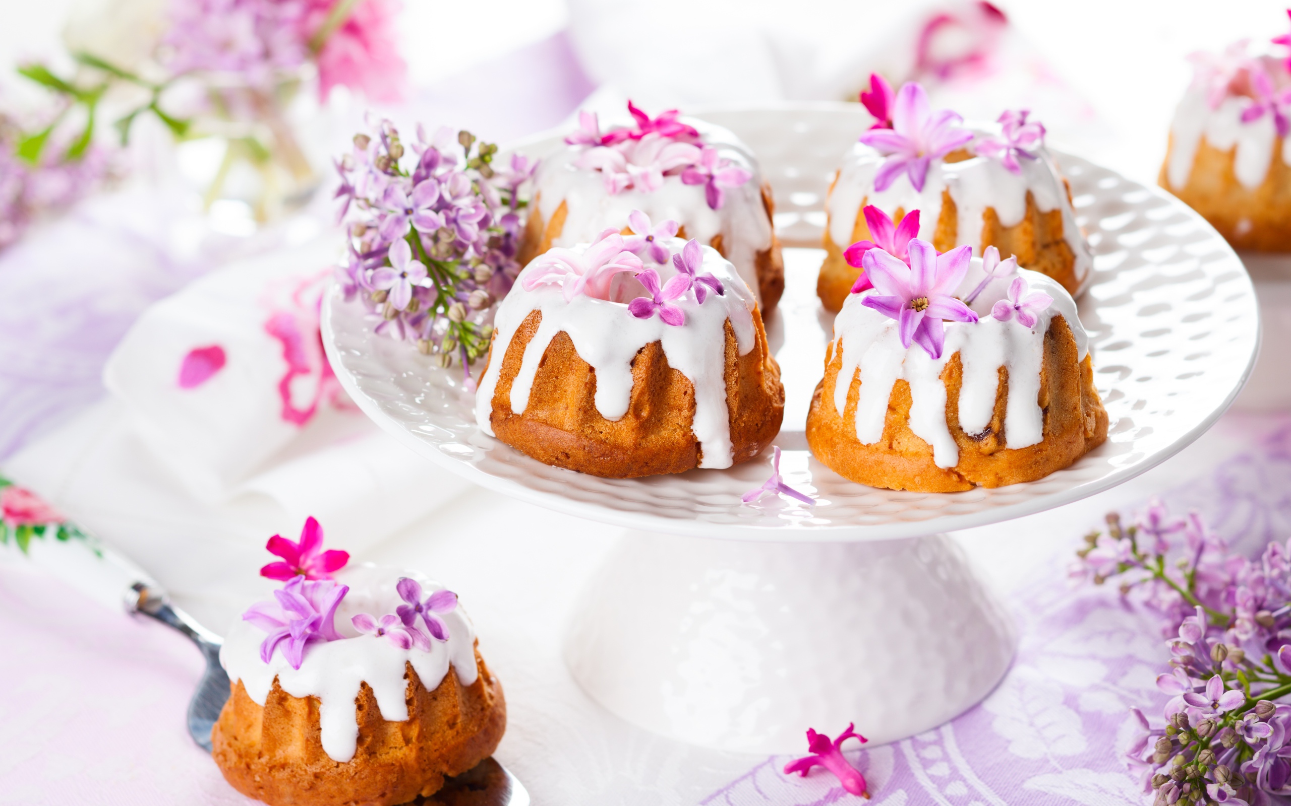 Кексы с глазурью на подносе с цветами сирени 