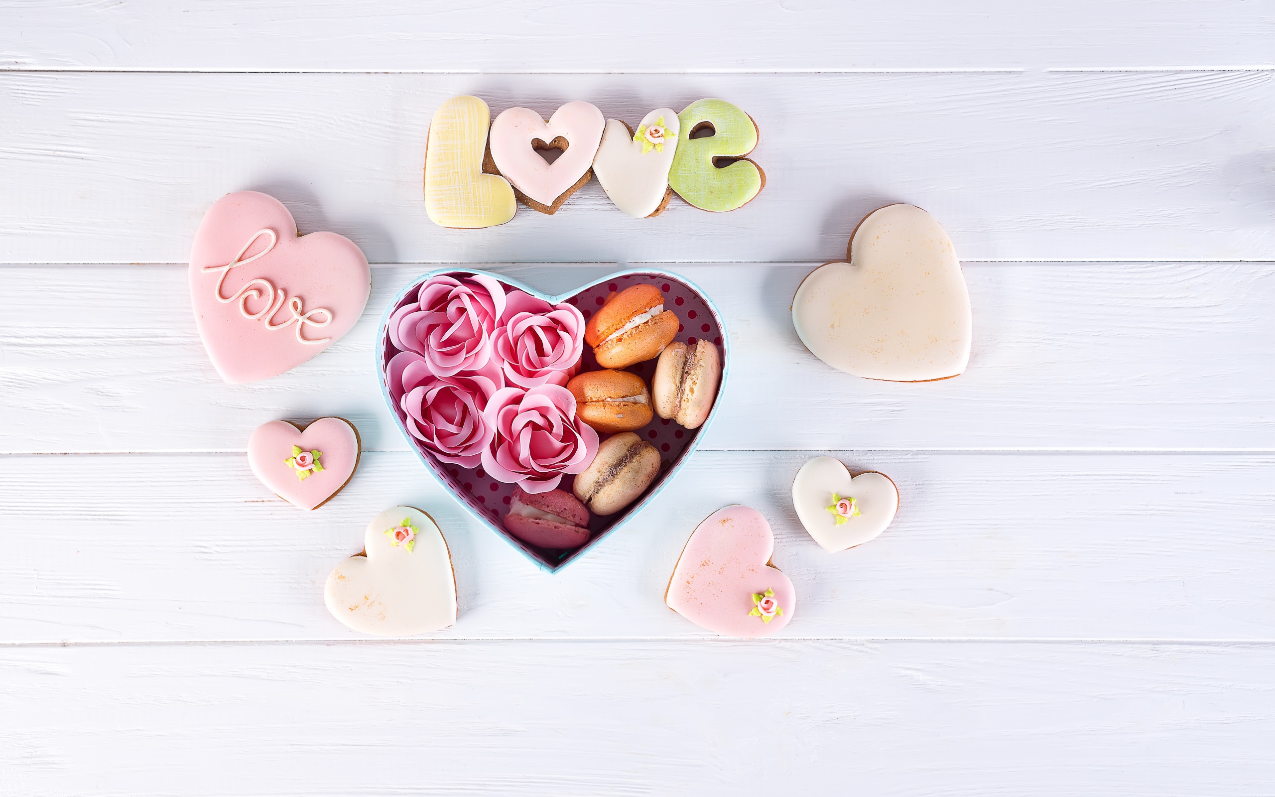 Печенье в форме сердца на столе с коробкой с десертом макарун
