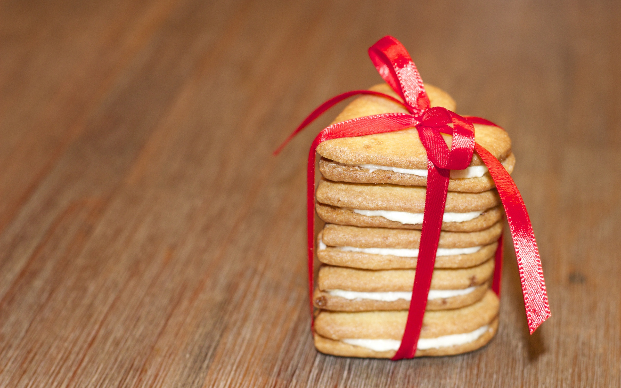 Печенье в форме сердца перевязано красной лентой 