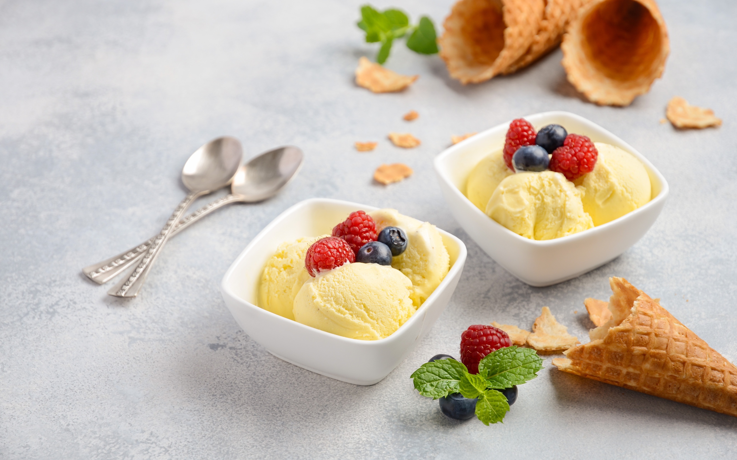 Шарики мороженого с ягодами на столе с вафельными рожками