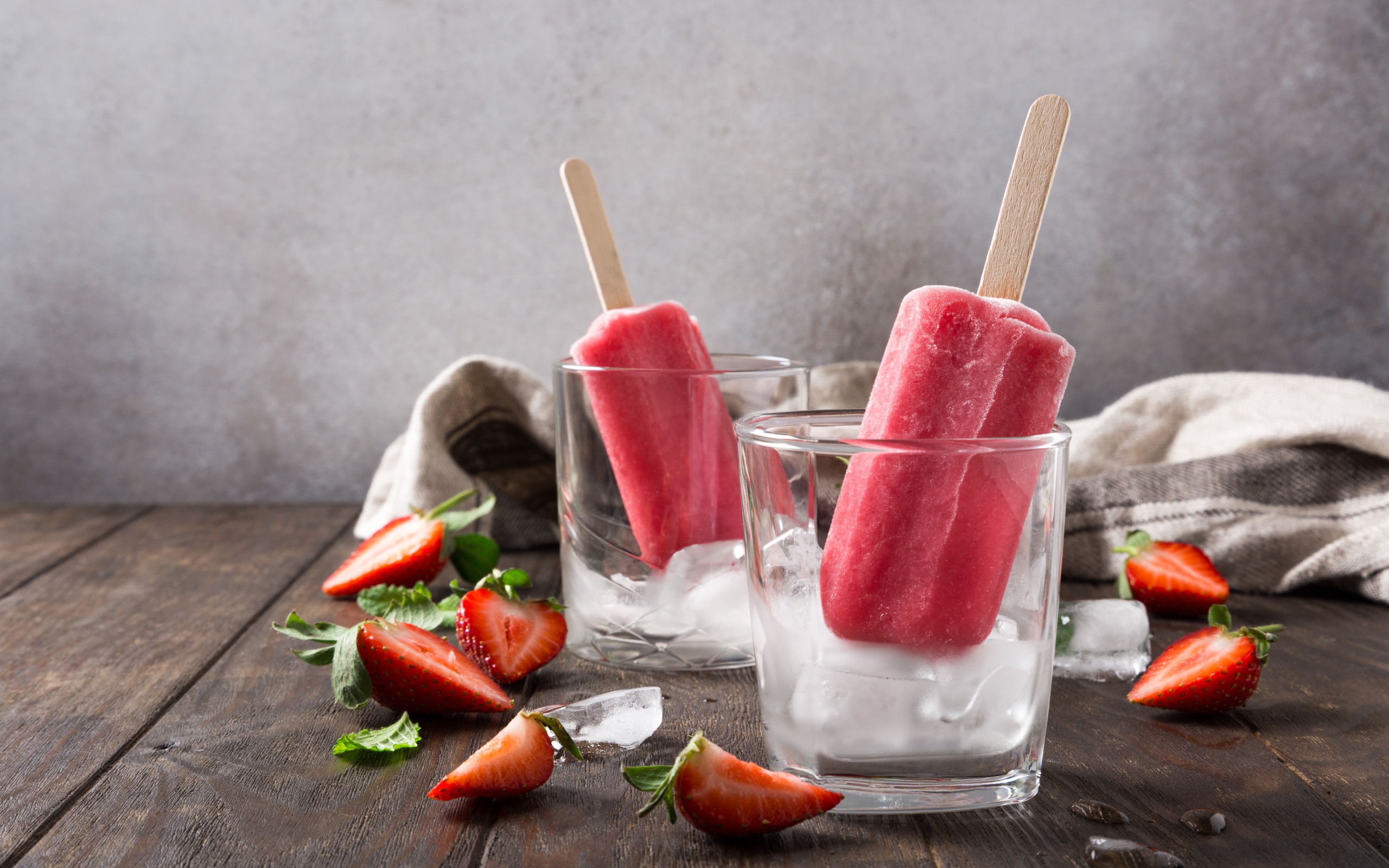 Фруктовое мороженое в стакане со льдом на столе с клубникой