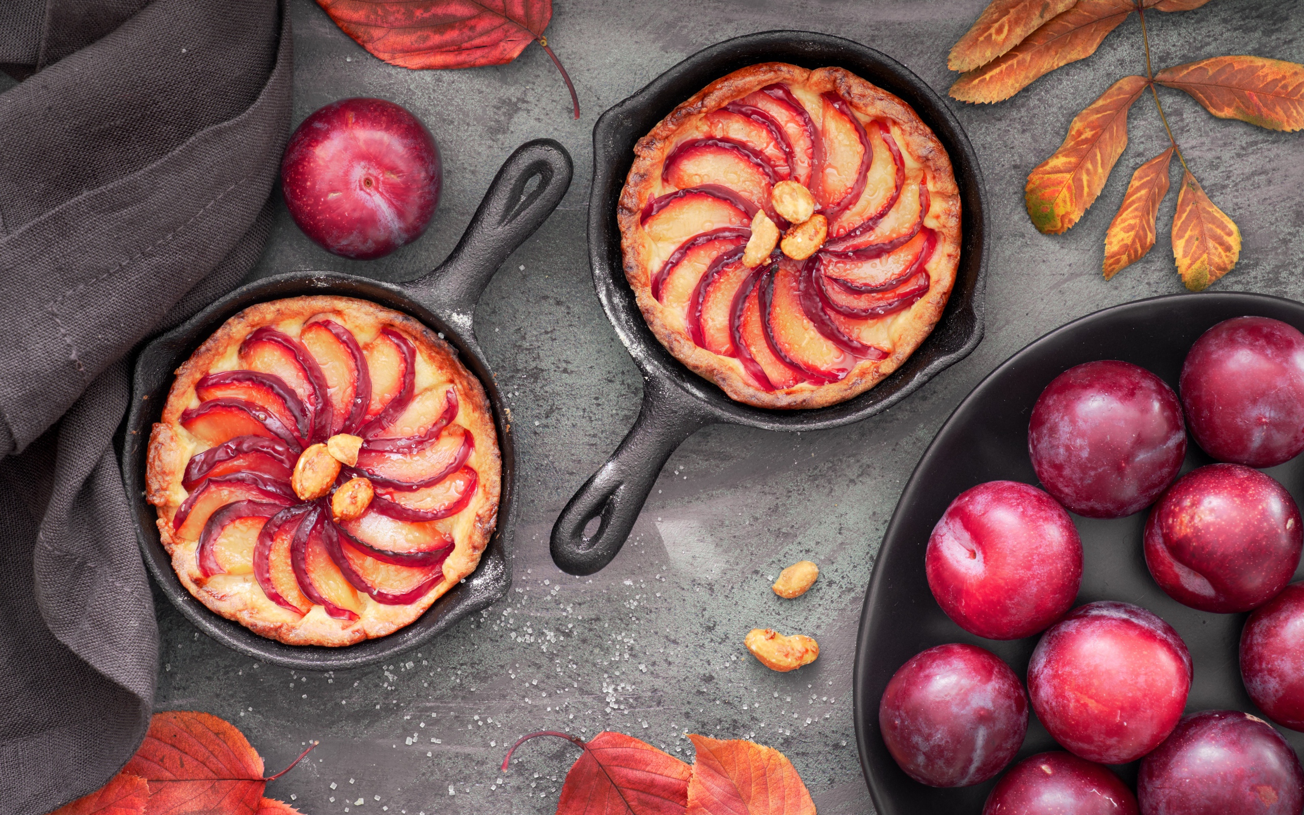 Пирог на столе с розовыми крупными сливами