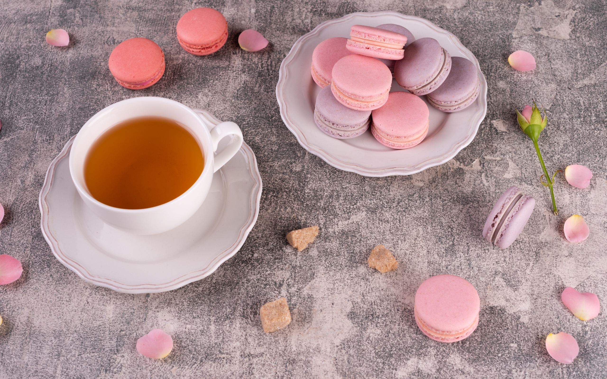 Тарелка с десертом макарун на столе с чашкой чая