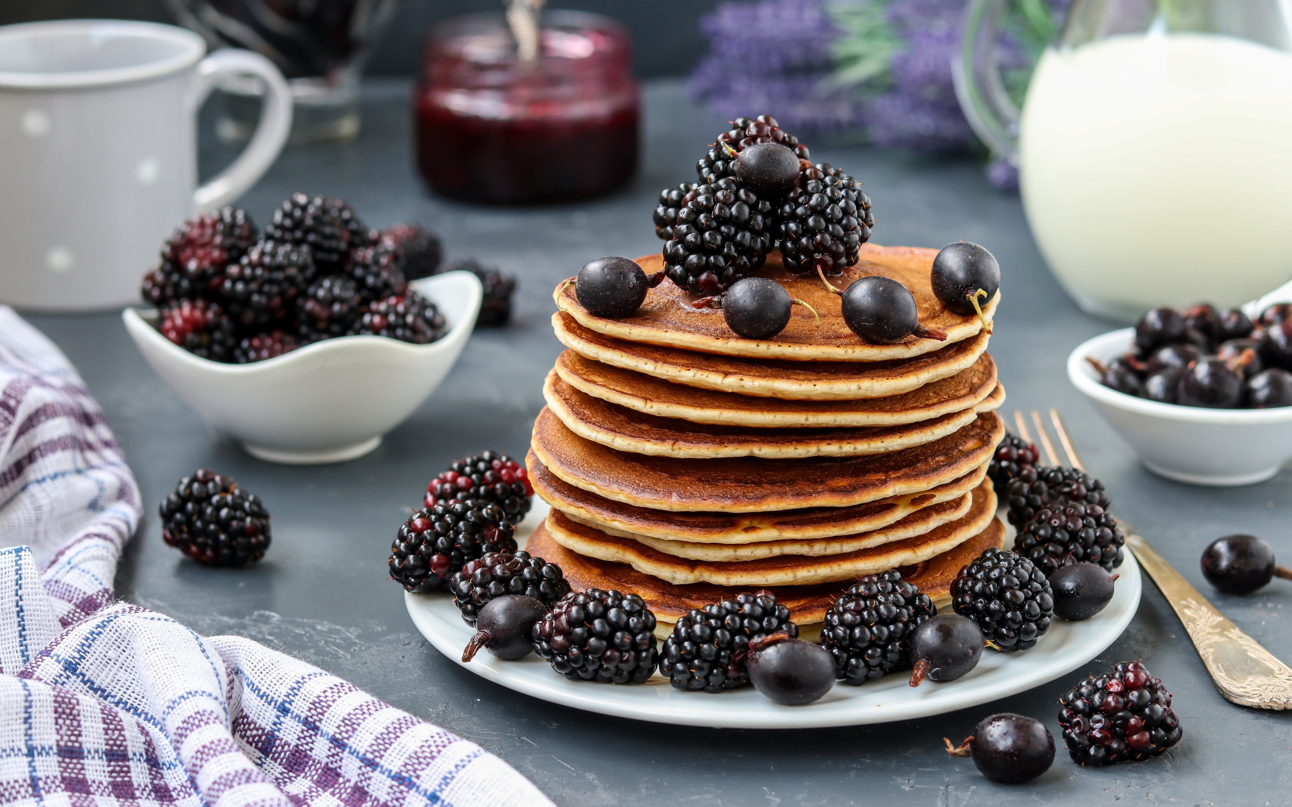 Румяные оладьи на тарелке с ягодами черники и смородины
