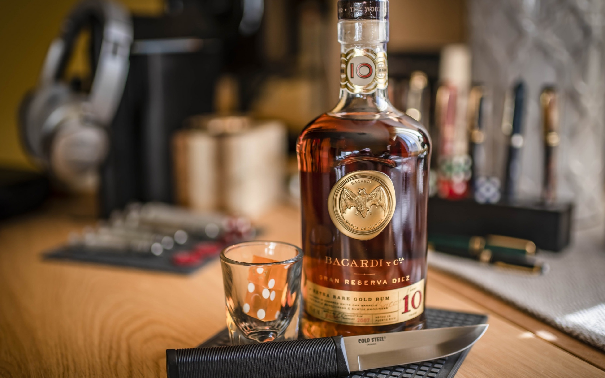 Бутылка виски на столе с рюмкой и ножом