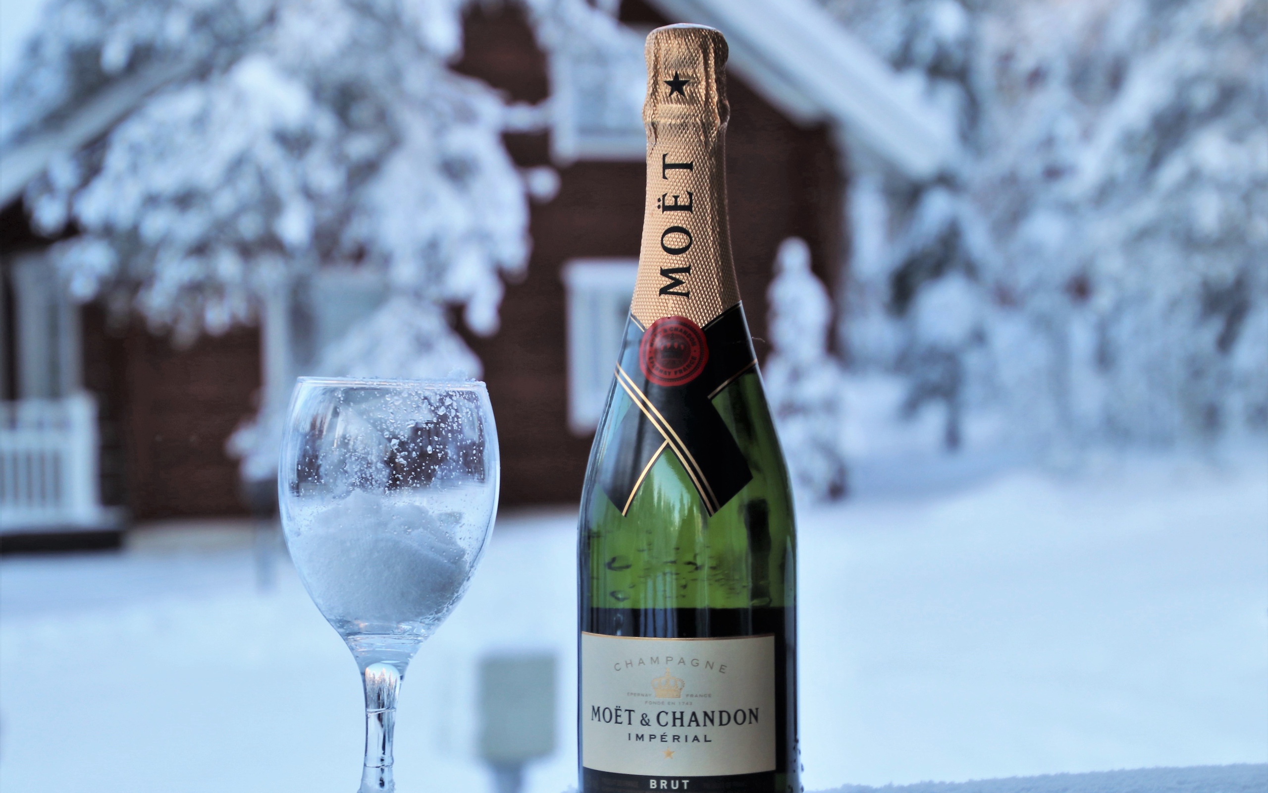 Бокал на снегу с бутылкой шампанского 