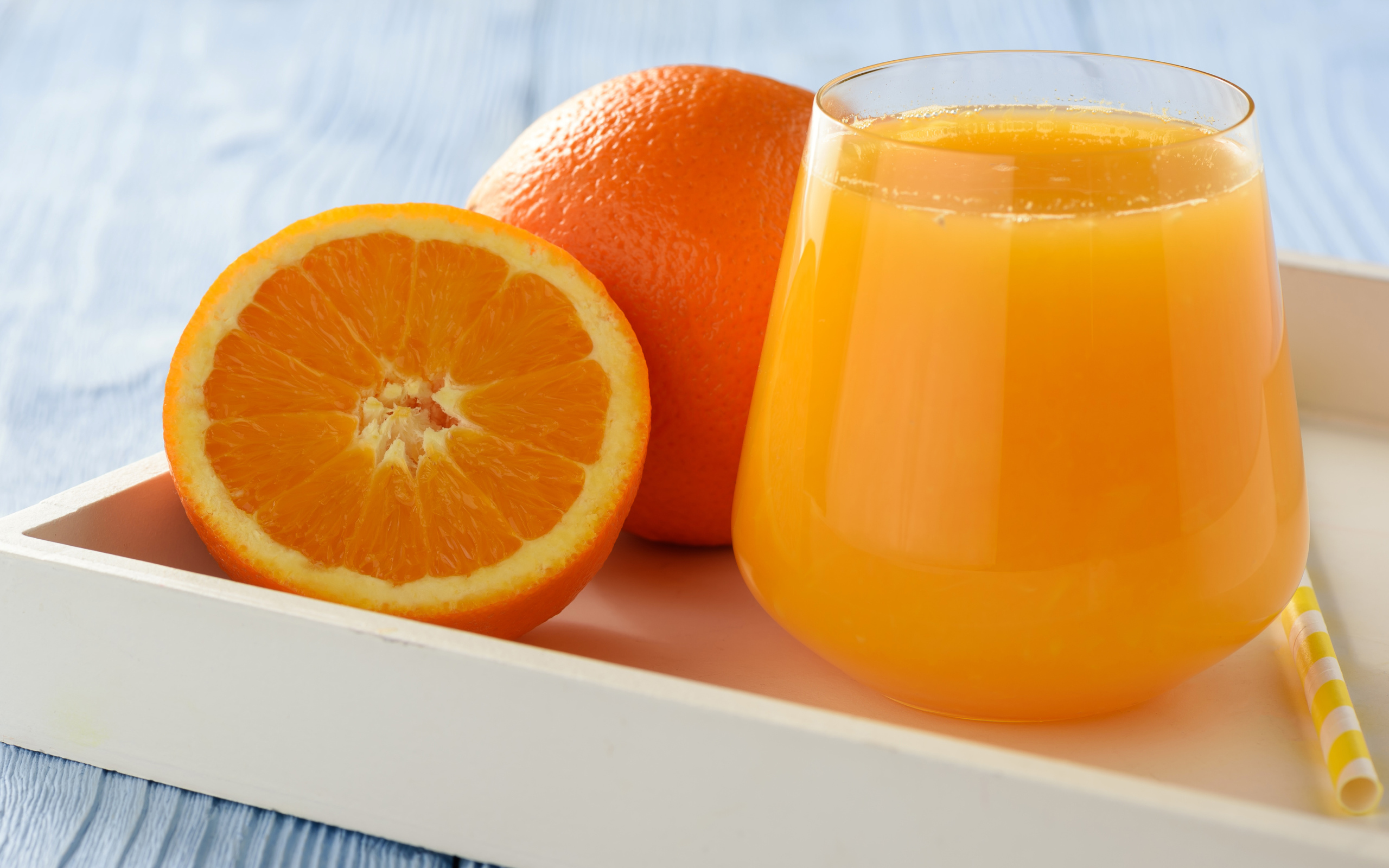 Стакан апельсинового сока на столе с апельсином 