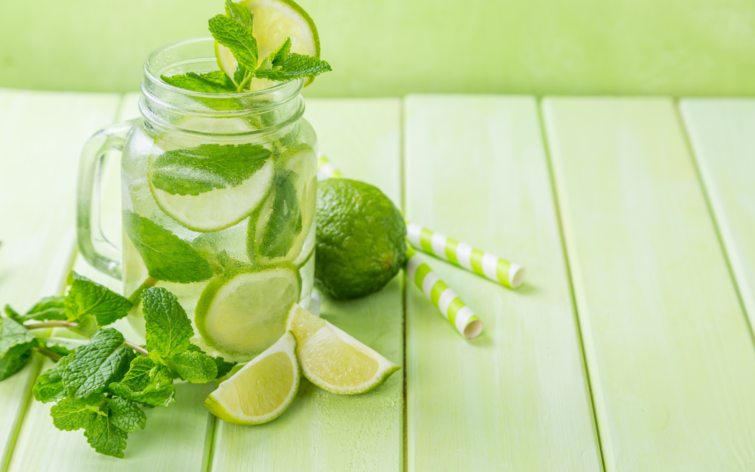 Графин с мохито на столе с лаймом и мятой