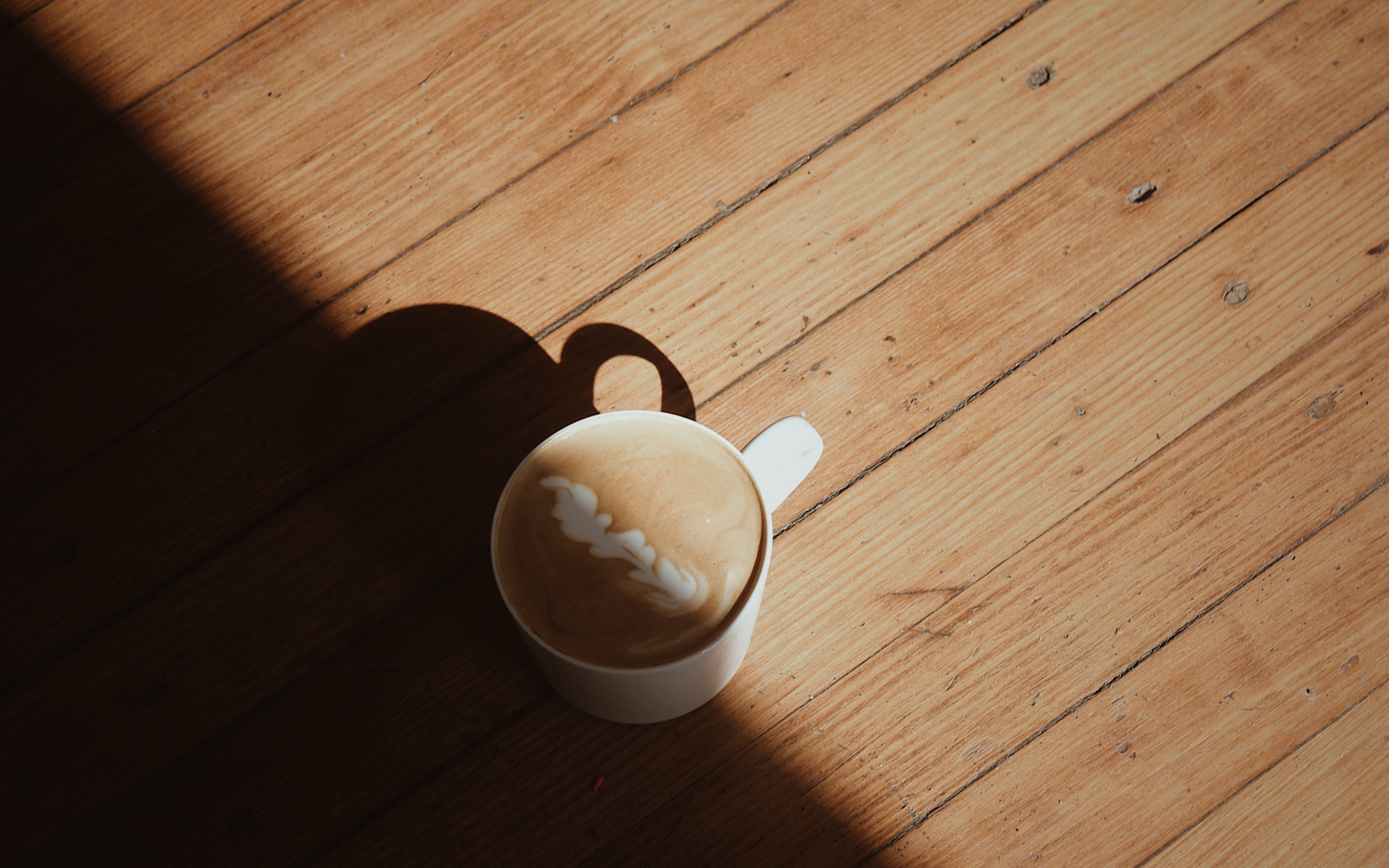 Чашка капучино с рисунком на деревянном столе
