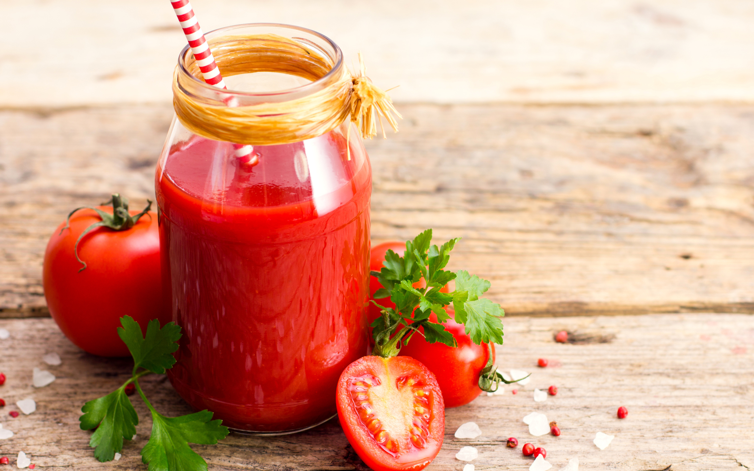 Банка томатного сока на столе с помидорами и петрушкой