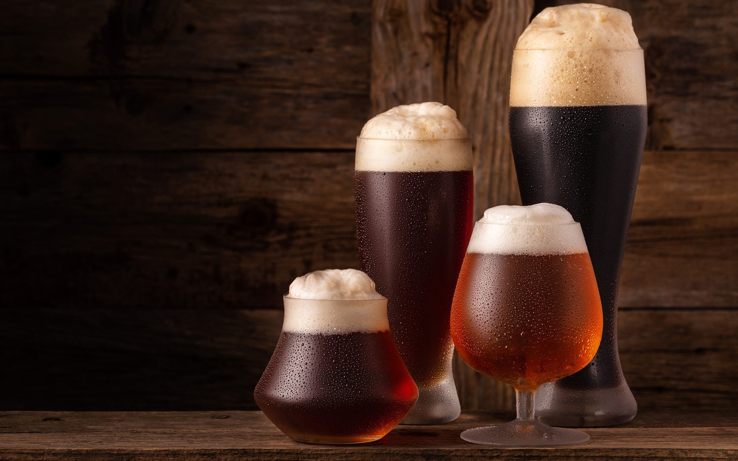 Много бокалов холодного пенного пива на столе 