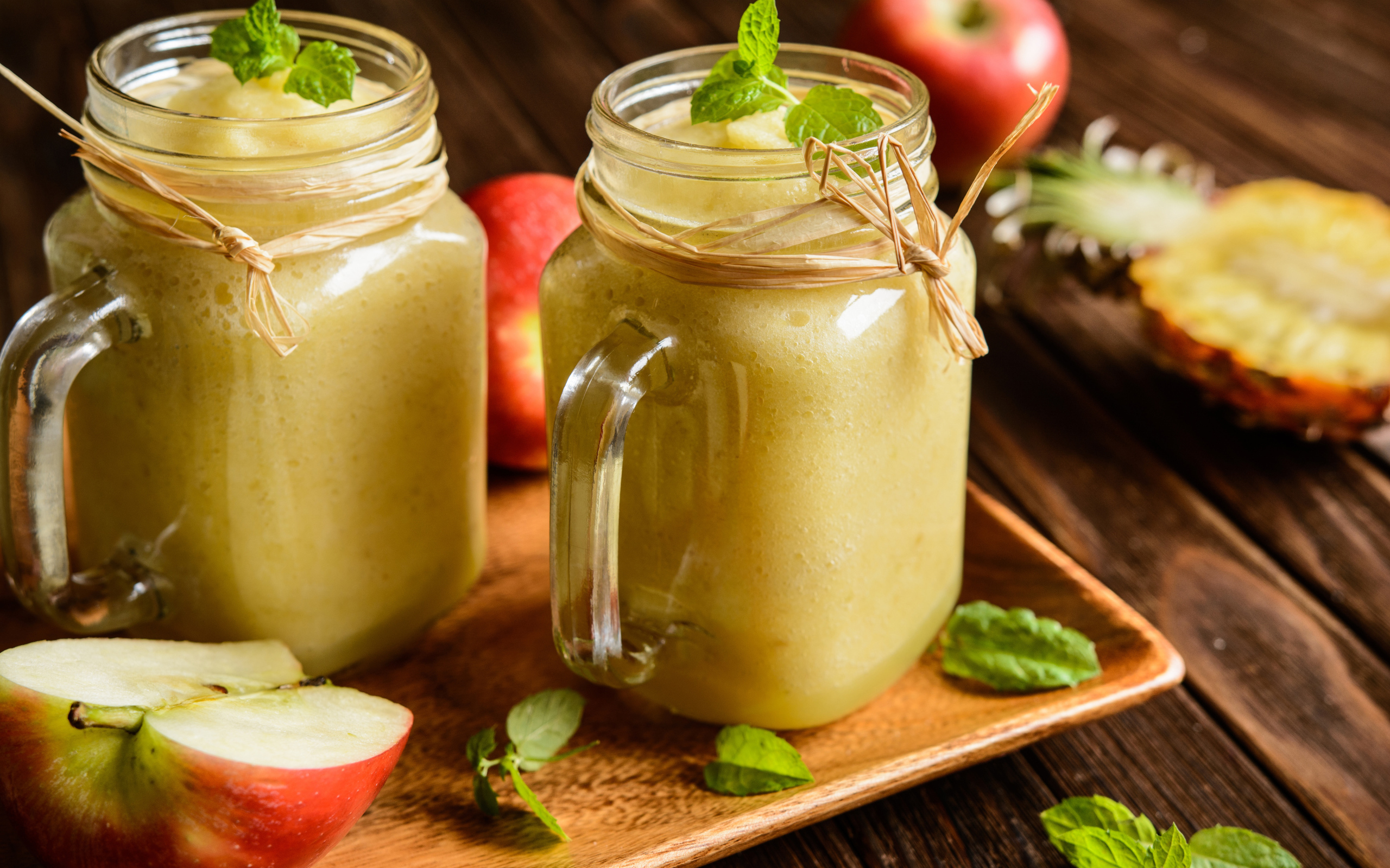 Смузи в стеклянных банках на столе с яблоками