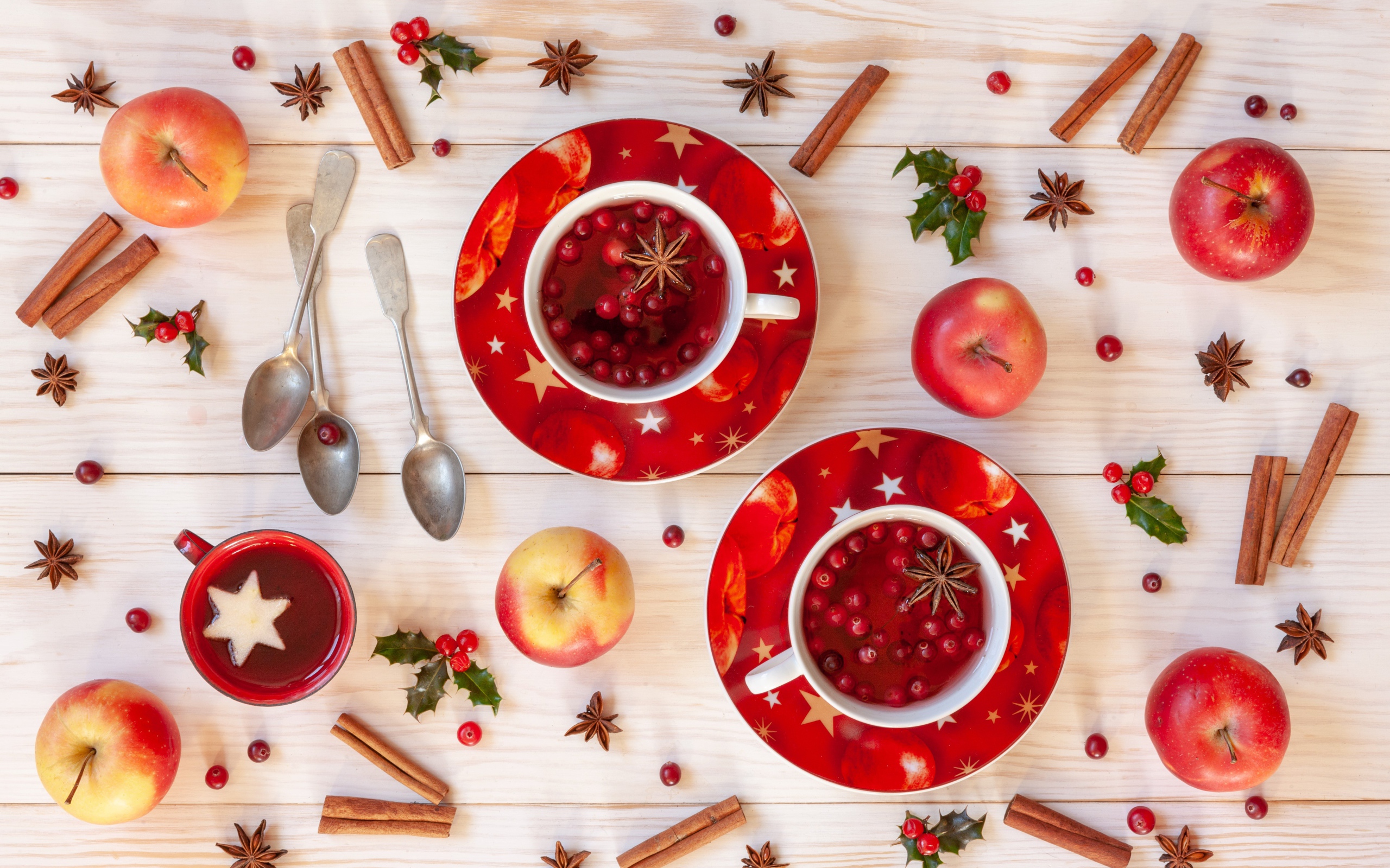 Две чашки клюквенного чая на столе с корицей, яблоками и бадьяном