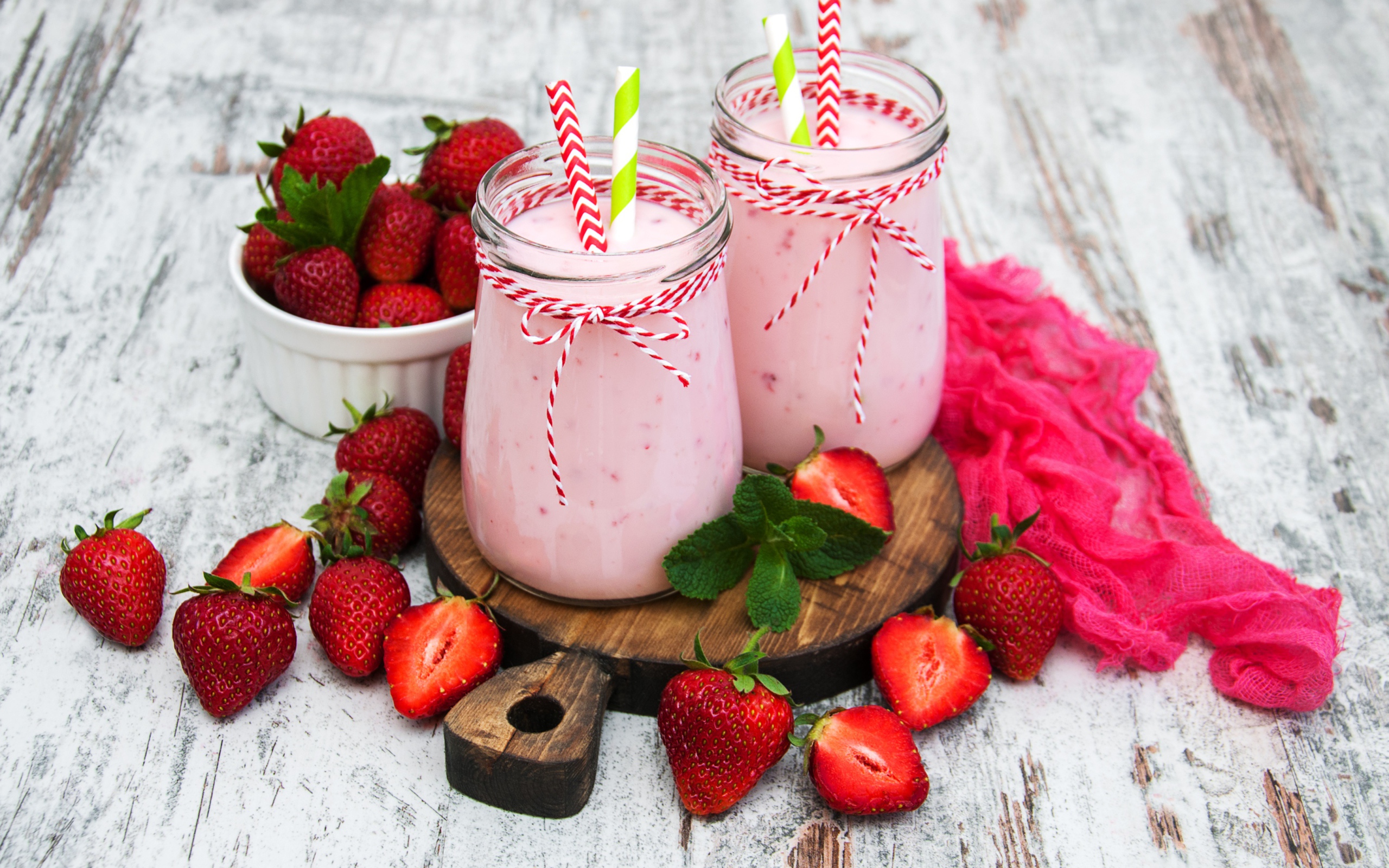 Две банки смузи стоят на доске на столе с клубникой