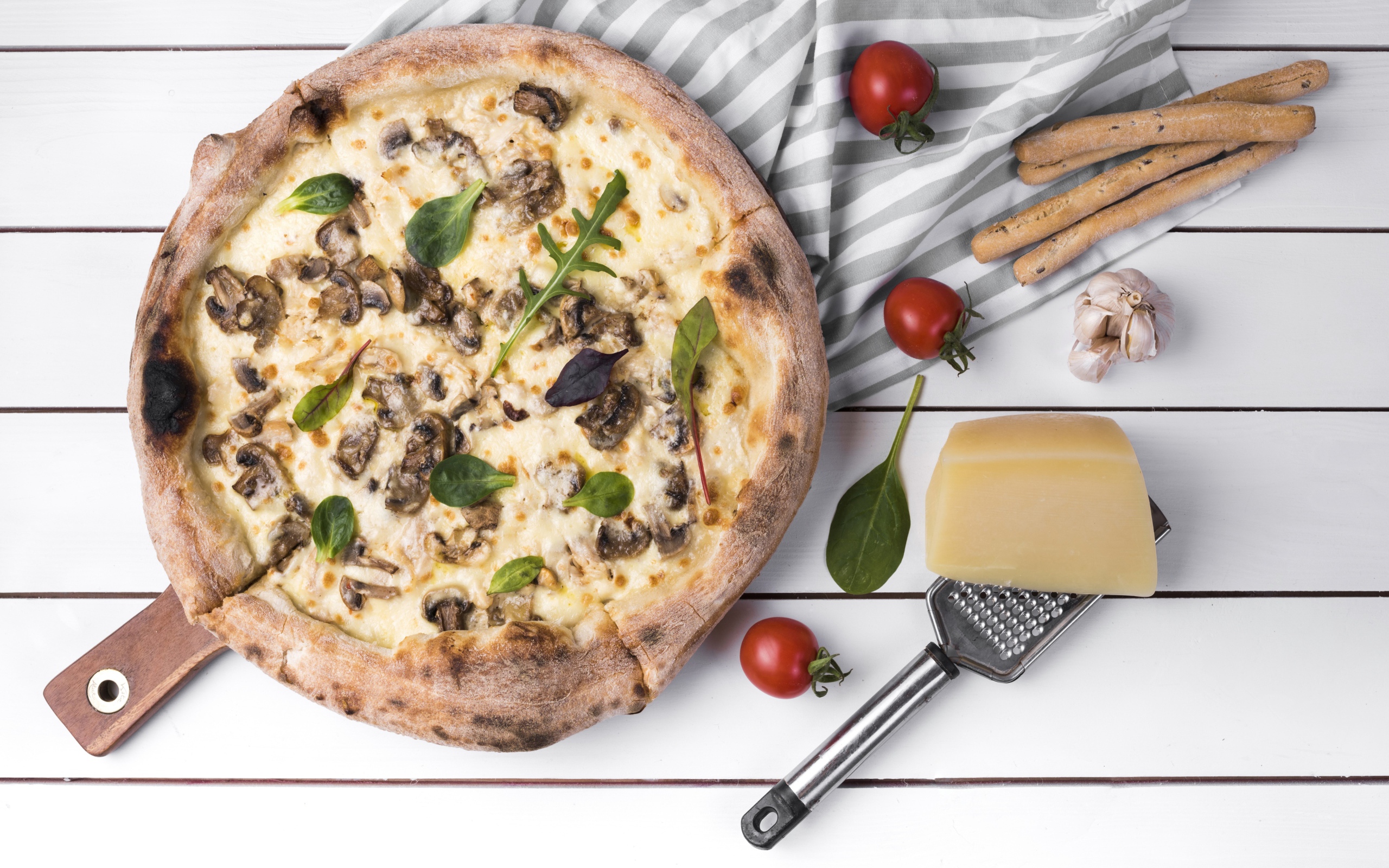 Пицца с грибами на столе с сыром и овощами