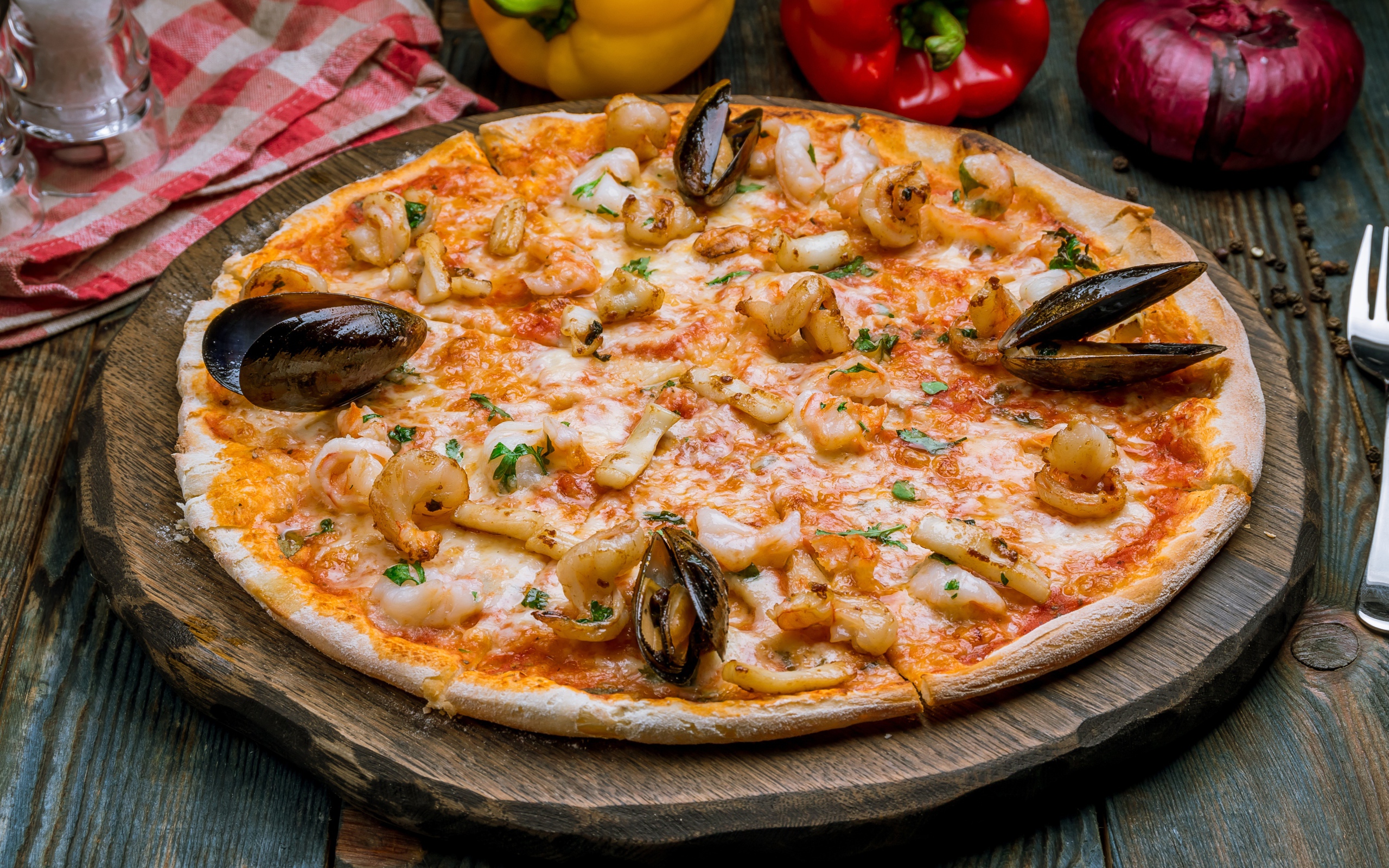 Вкусная пицца с морепродуктами на деревянной доске