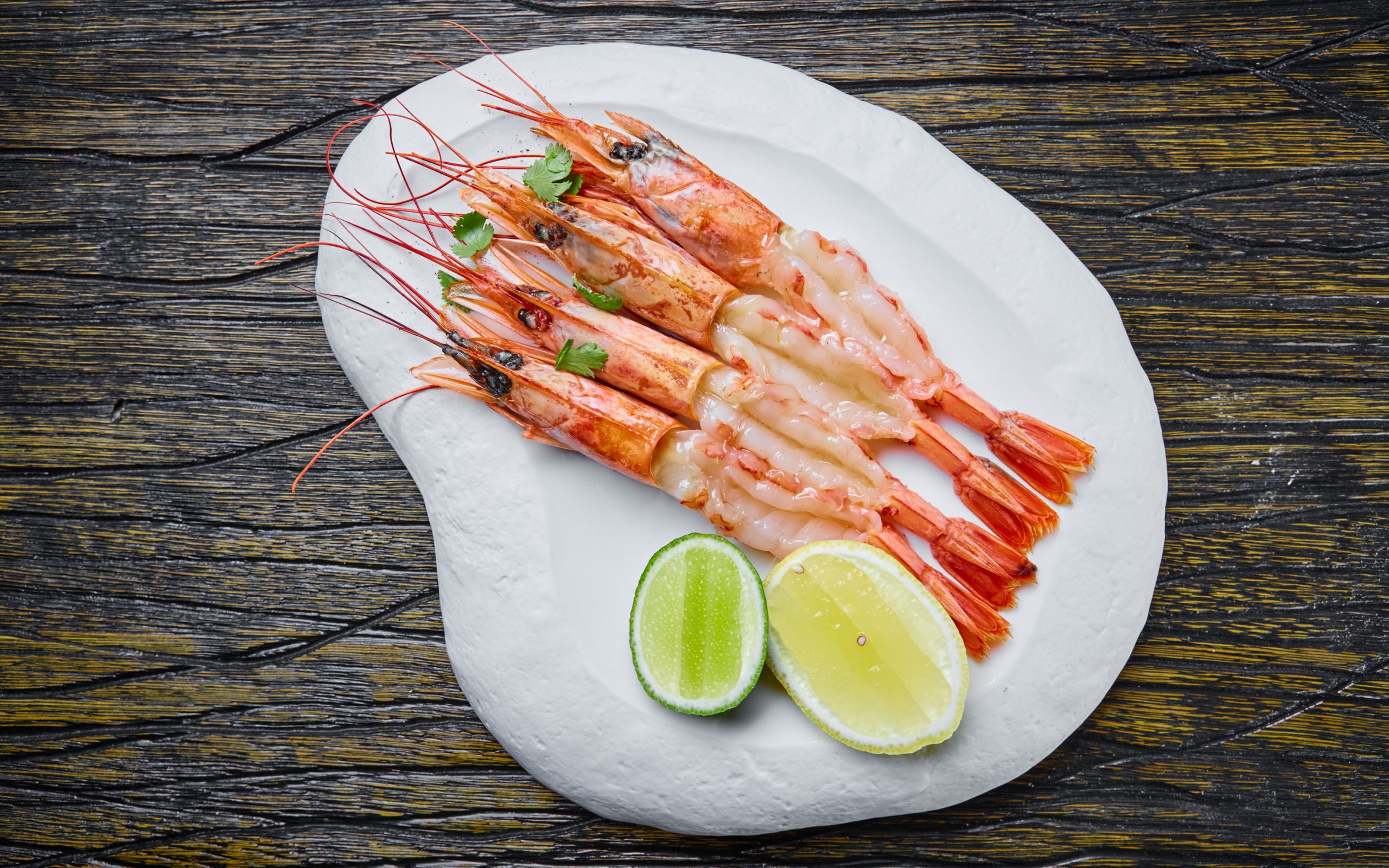Аппетитные креветки на белой тарелке с лимоном
