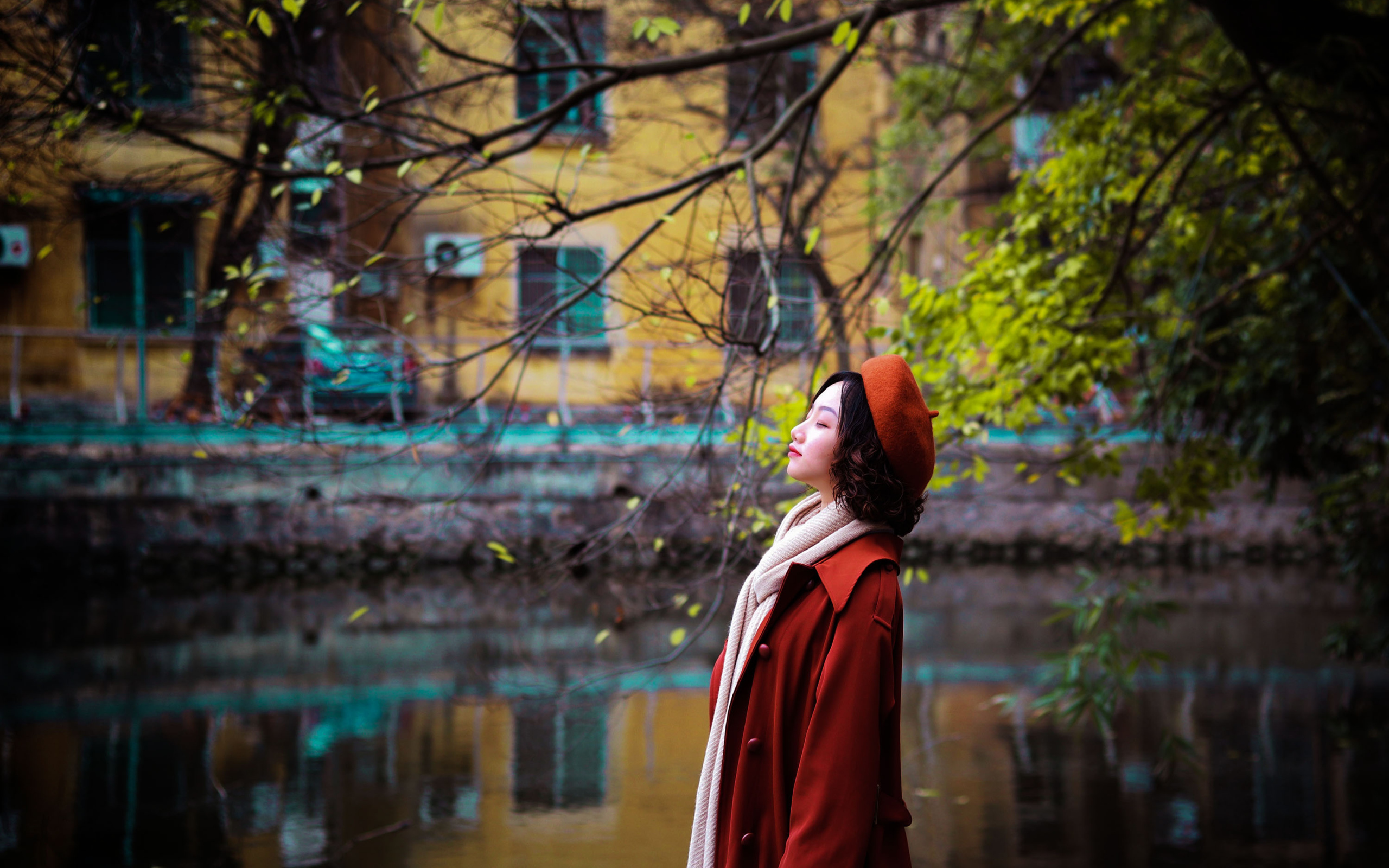 Девушка азиатка в красном пальто у воды