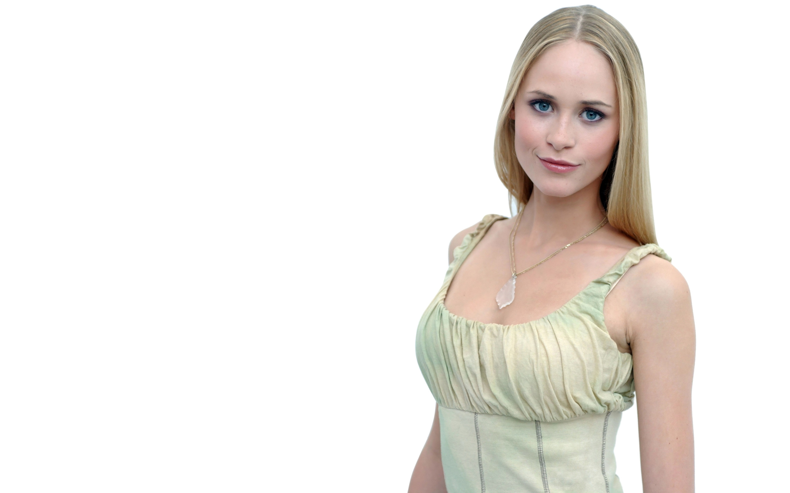 Красивая голубоглазая блондинка на белом фоне с кулоном на шее 