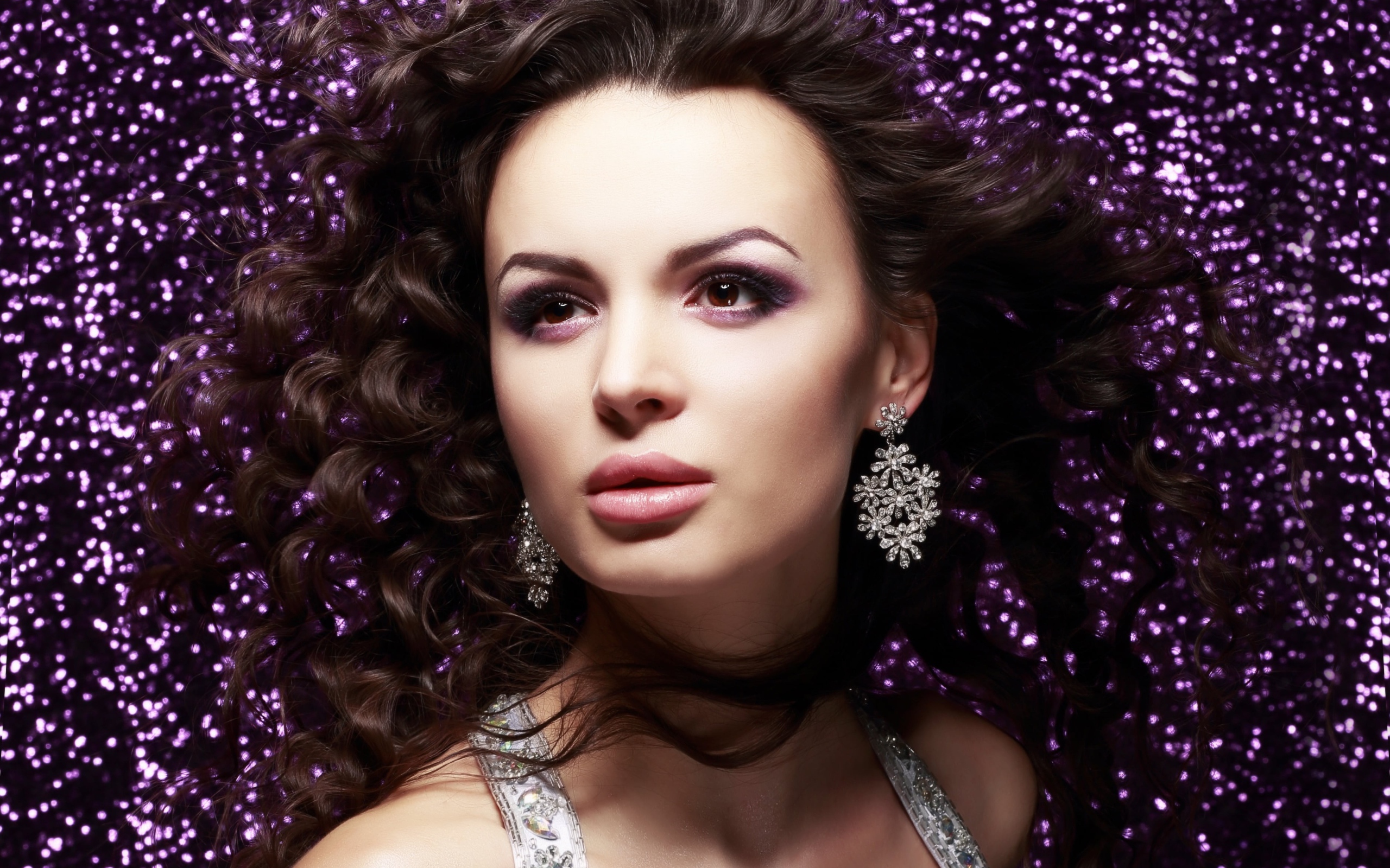 Красивая шатенка на блестящем фоне