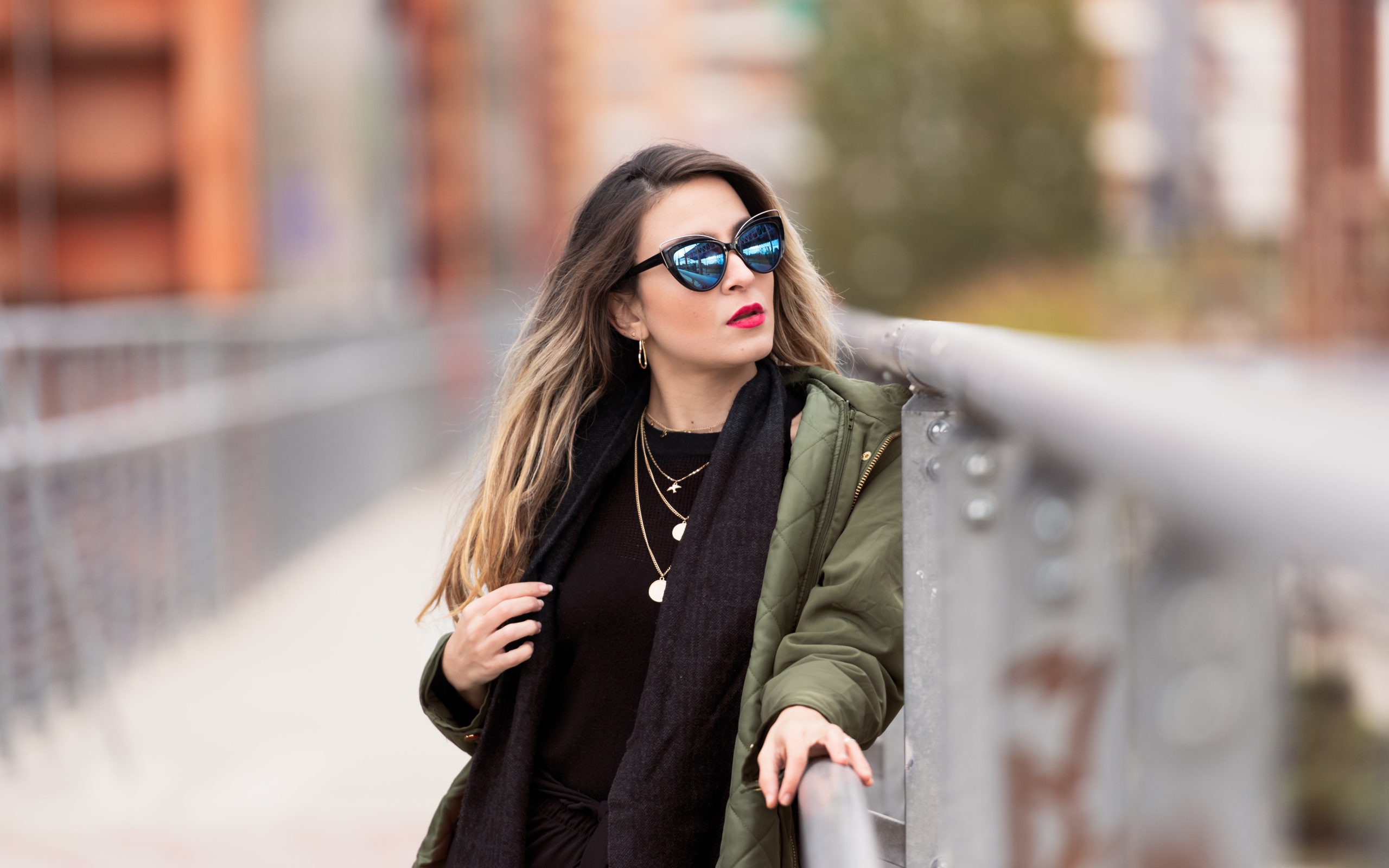 Красивая девушка в солнечных очках на мосту