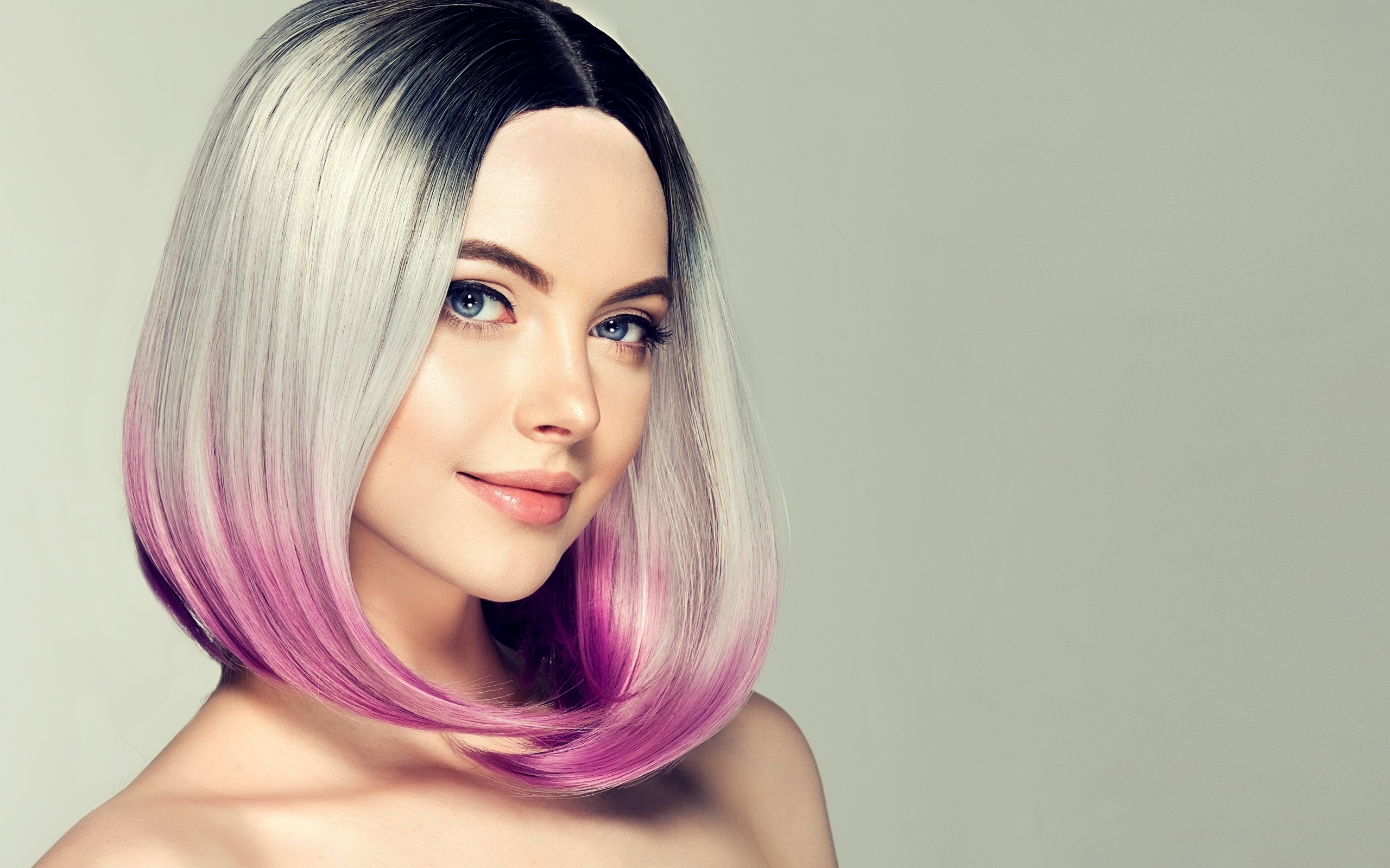 Красивая девушка с крашеными волосами на сером фоне