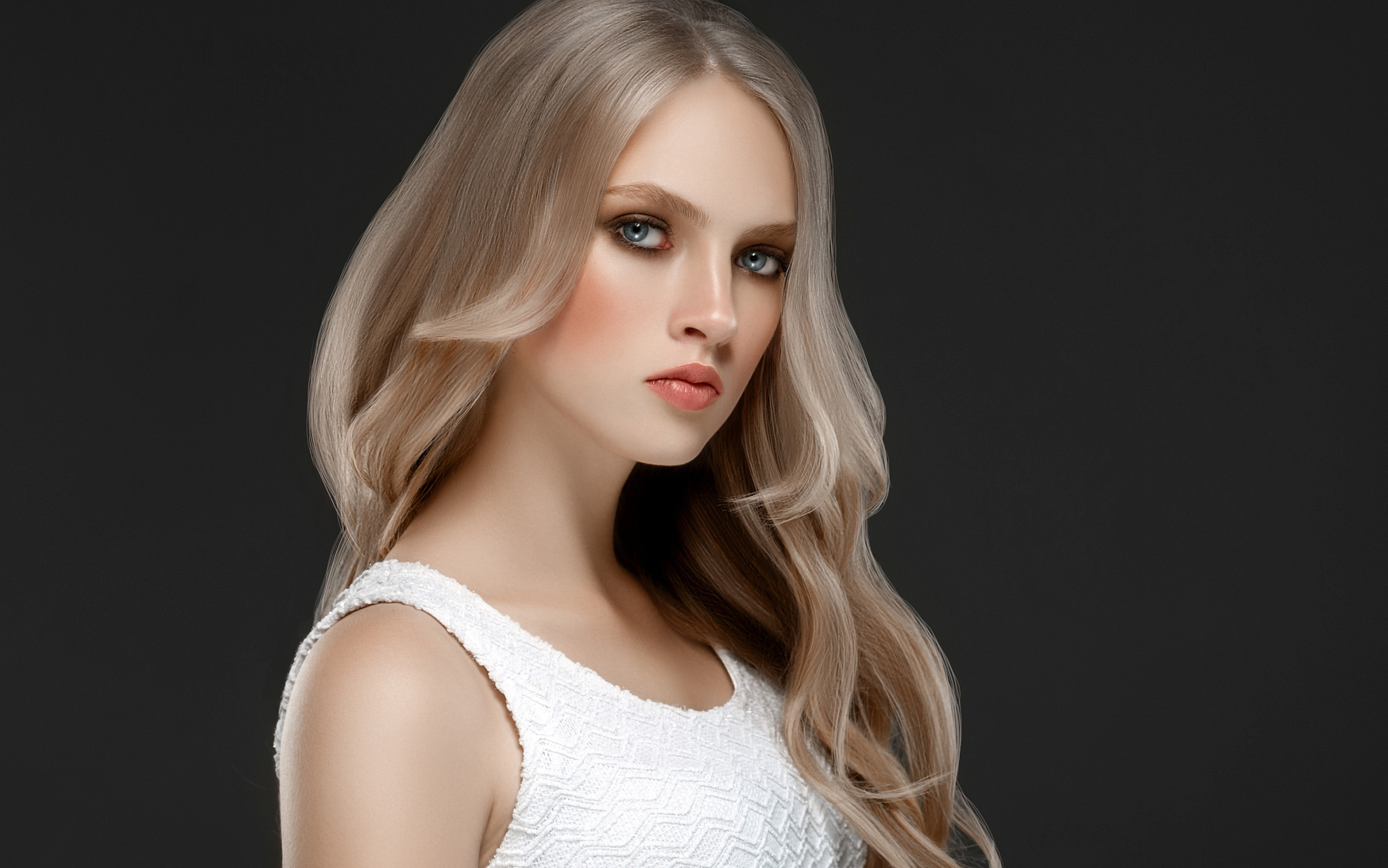 Красивая девушка с длинными  белыми волосами на сером фоне