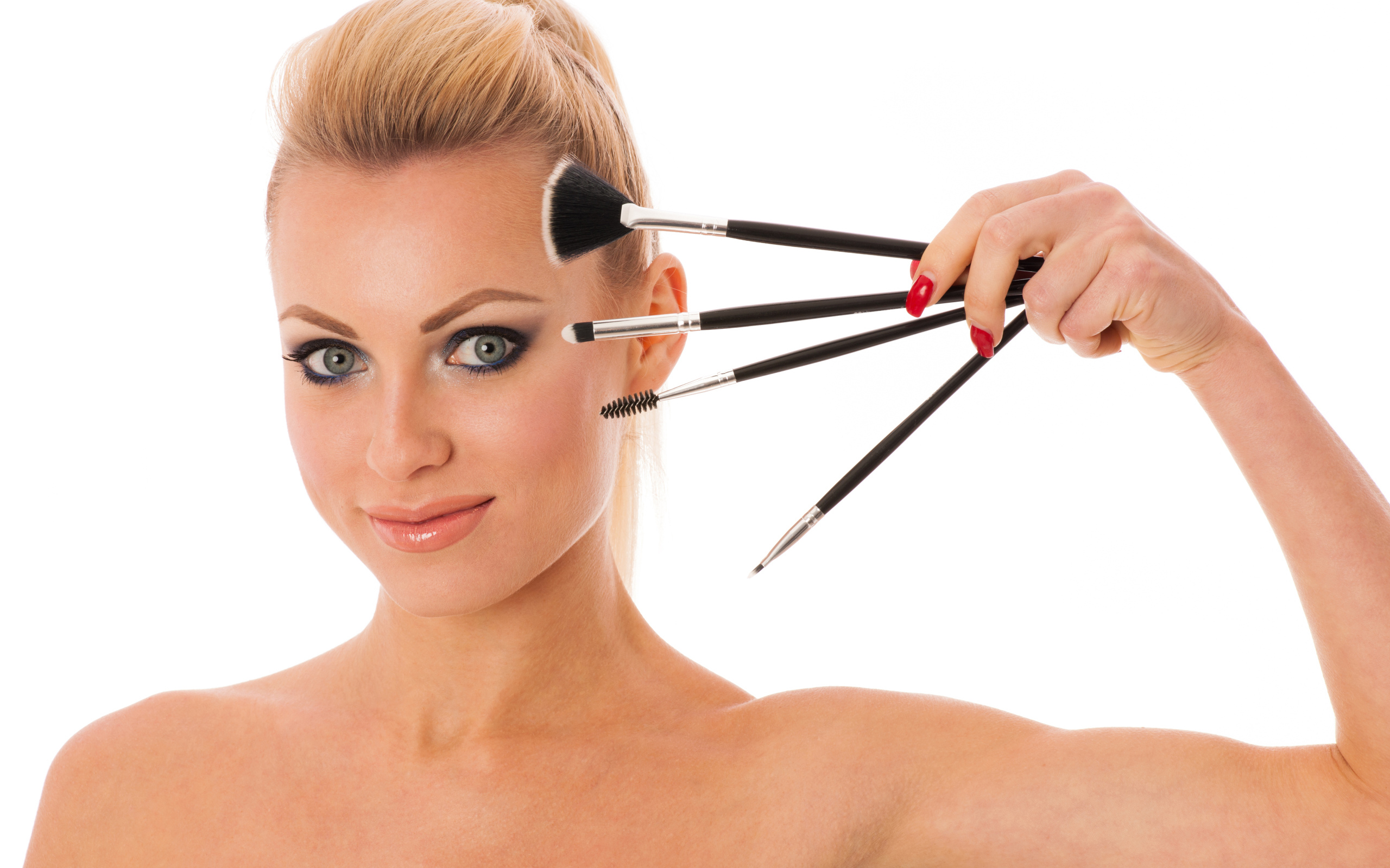 Красивая девушка с кистями для макияжа на белом фоне