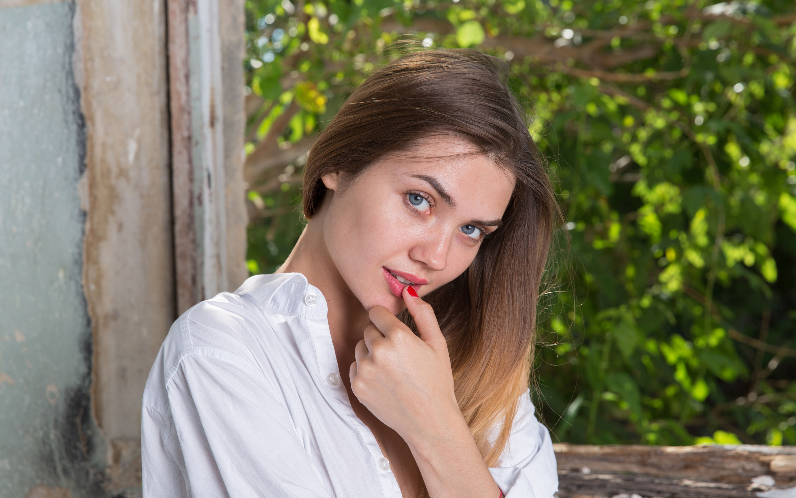 Красивая нежная девушка с серыми глазами с пальцем у рта