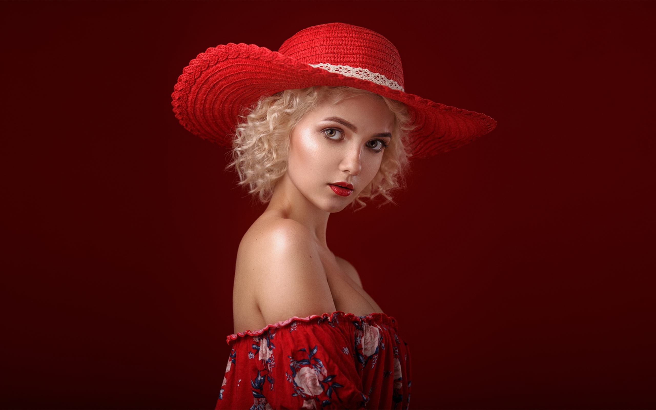 Блондинка в шляпе на красном фоне