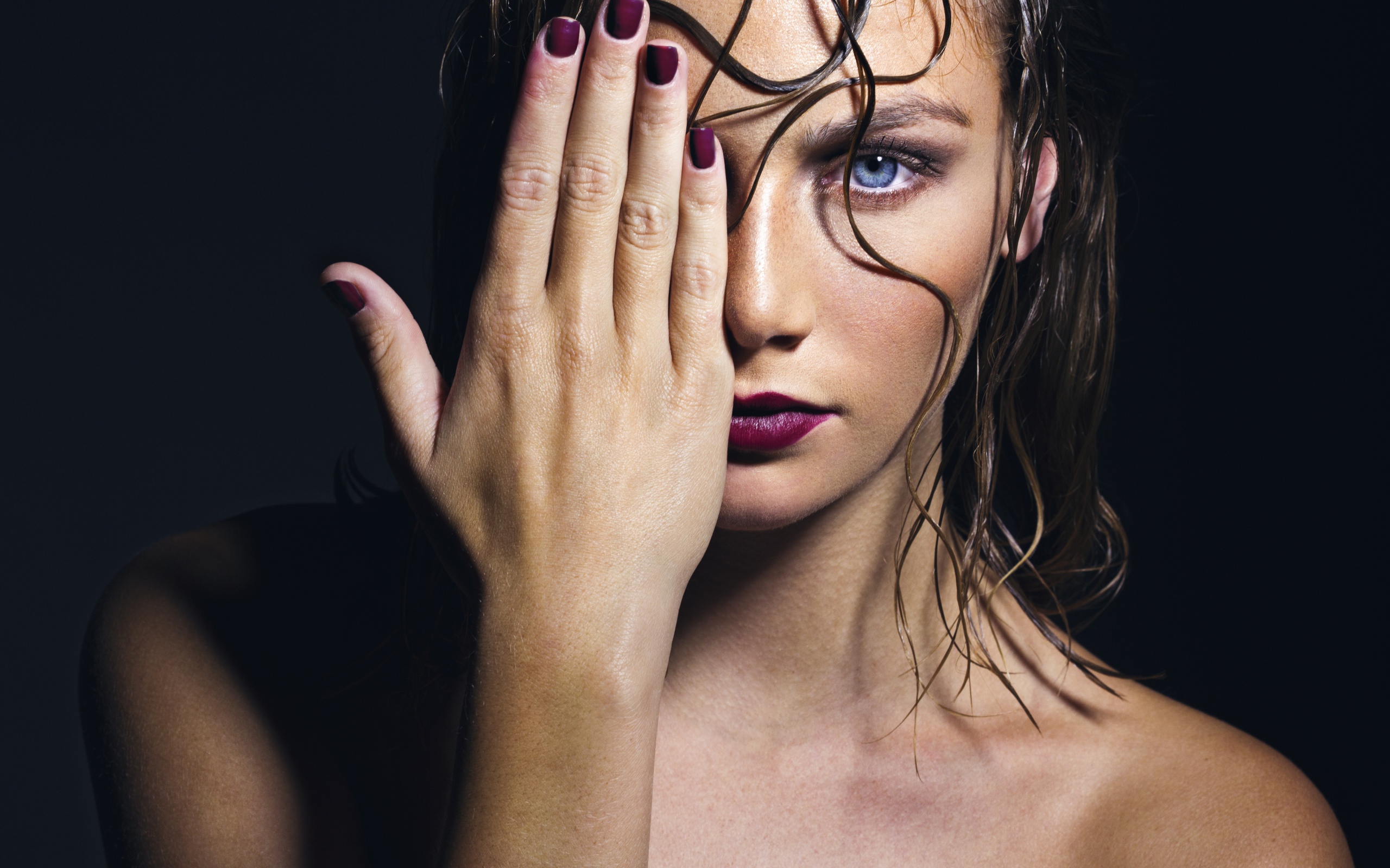 Голубоглазая девушка закрывает лицо рукой