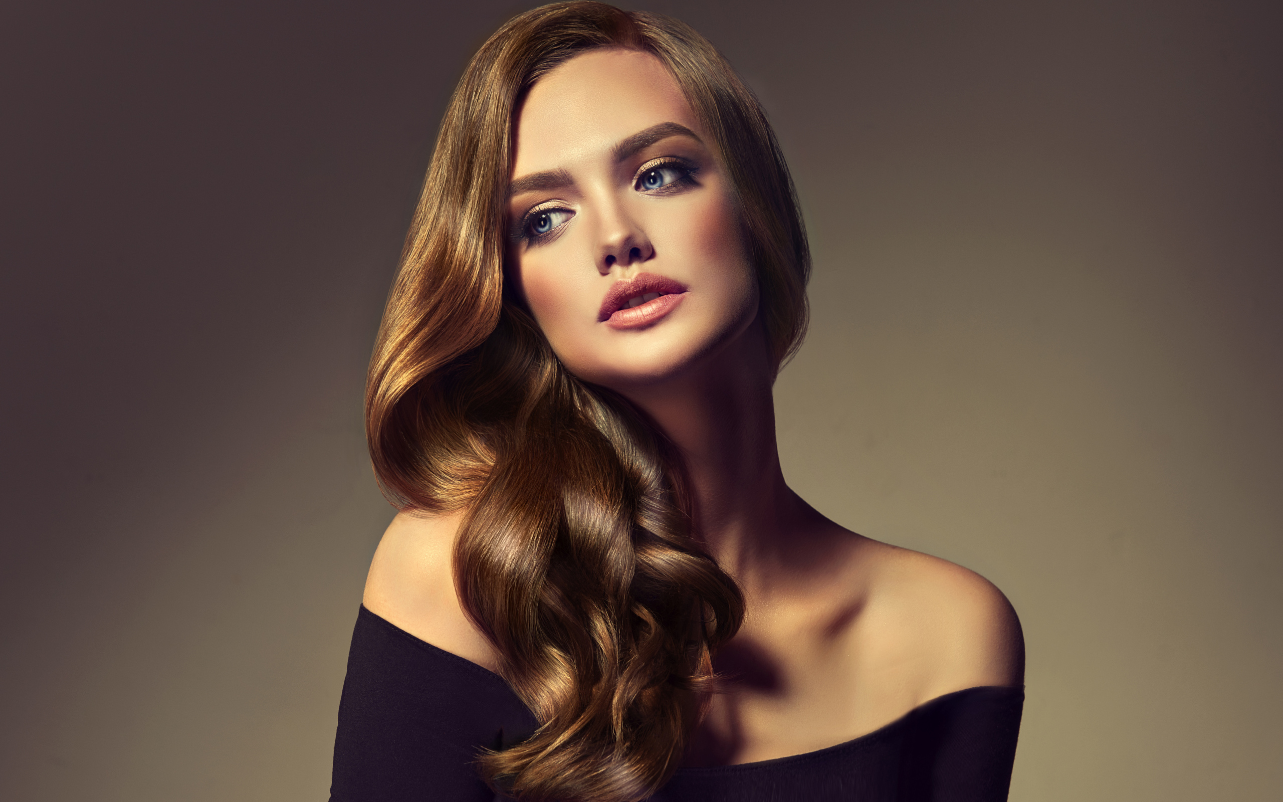 Нежная голубоглазая модель с длинными волосами на сером фоне