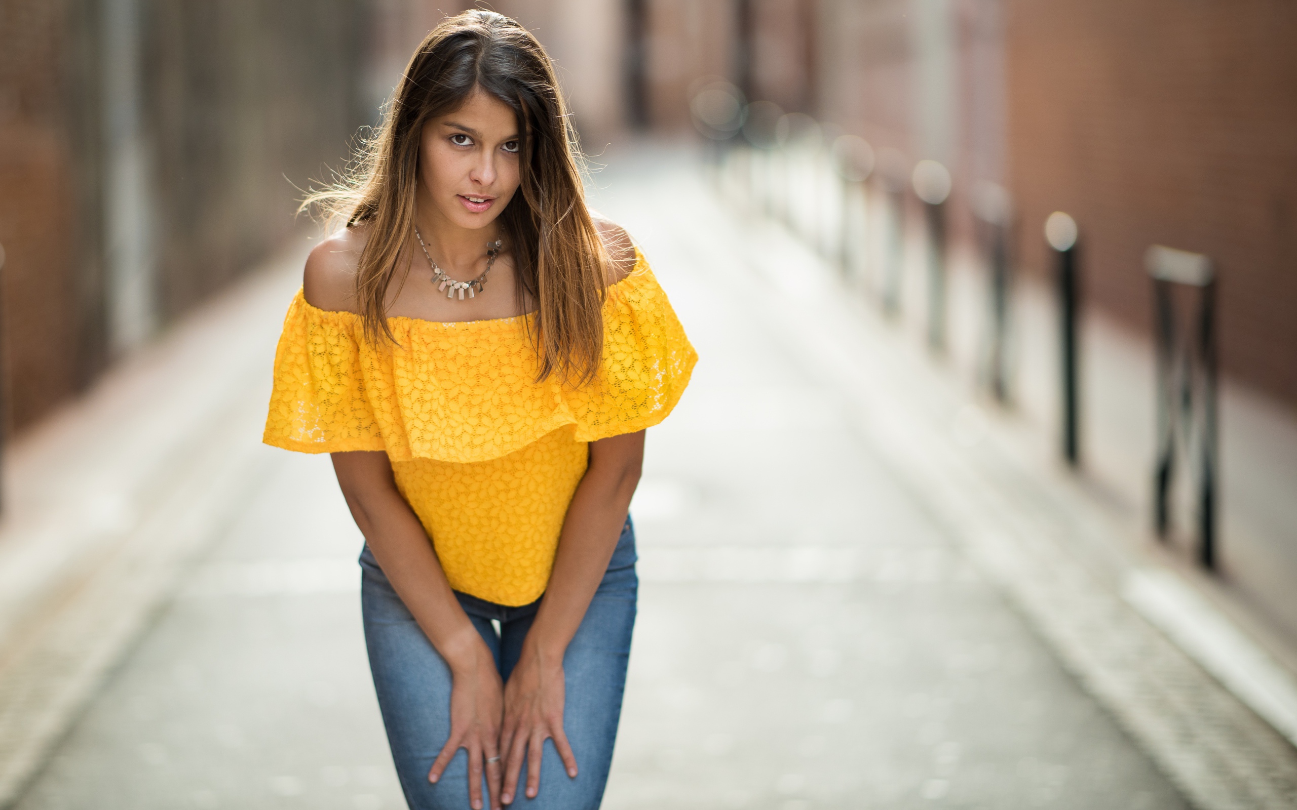 Девушка в джинсах стоит на улице 