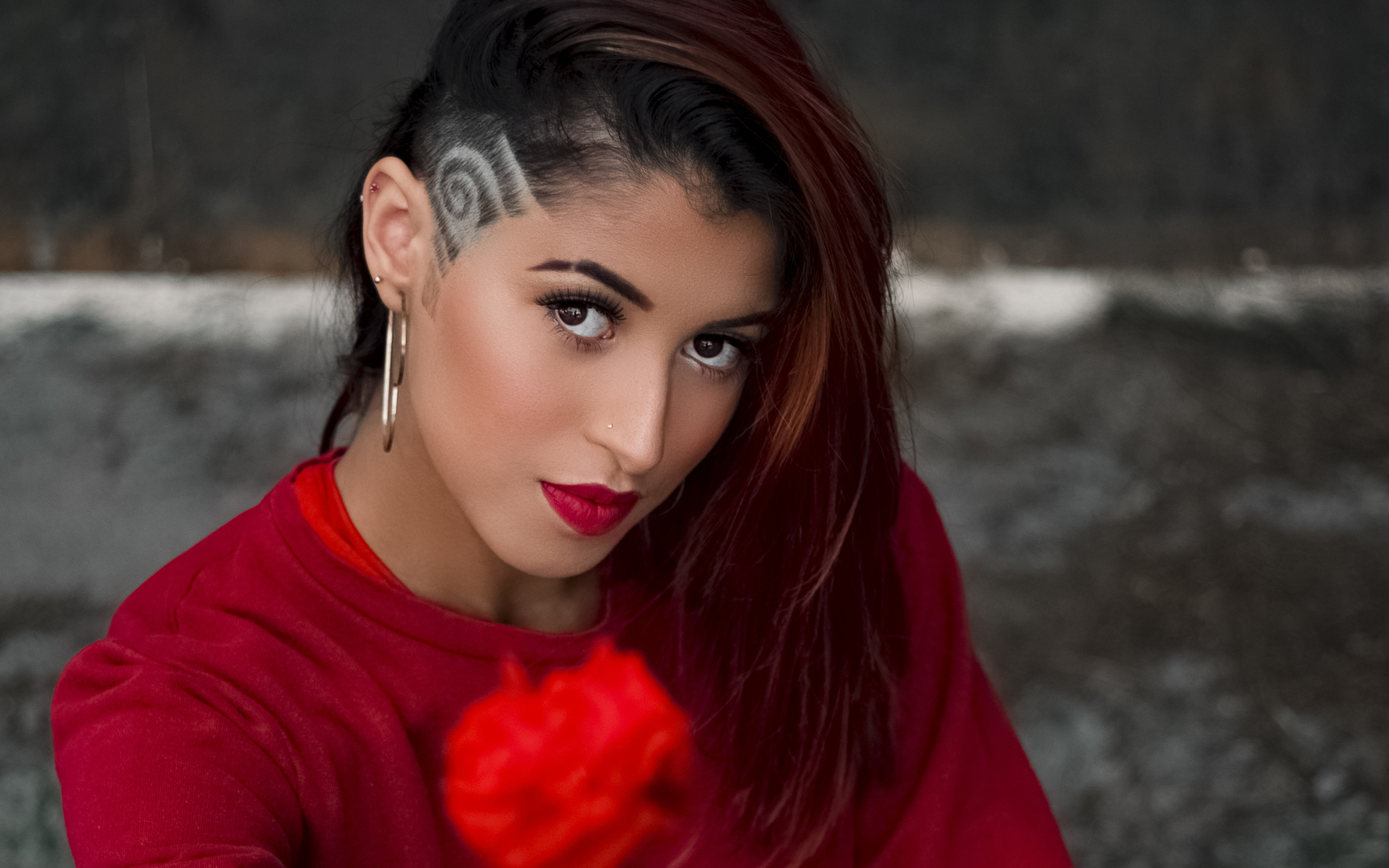 Девушка со стрижкой держит розу в руке