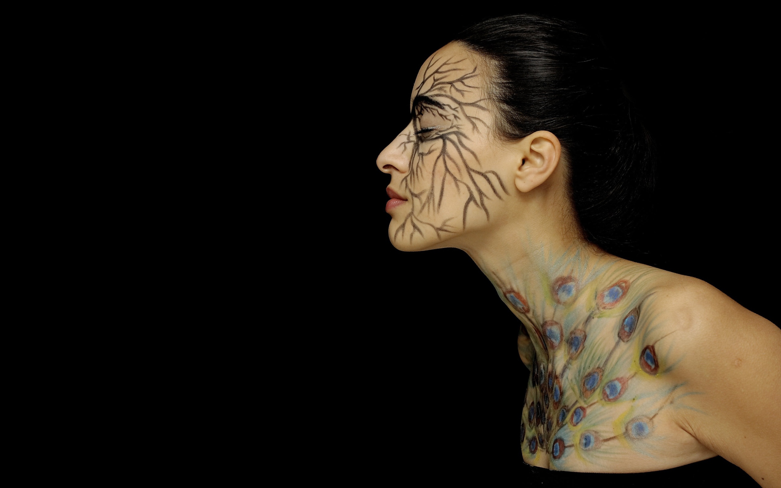 Девушка с рисунками на теле на черном фоне