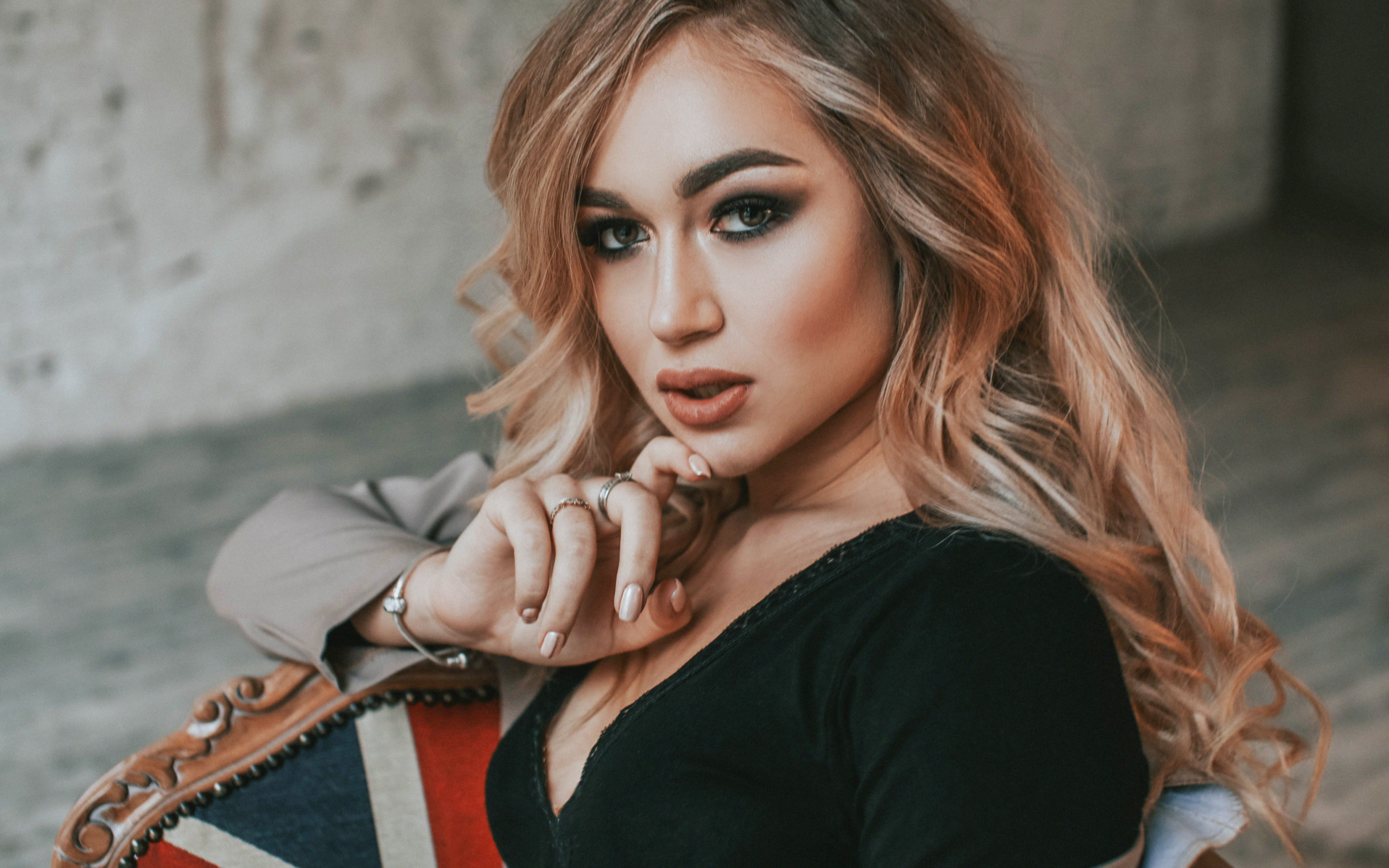 Горячая девушка с макияжем сидит на стуле