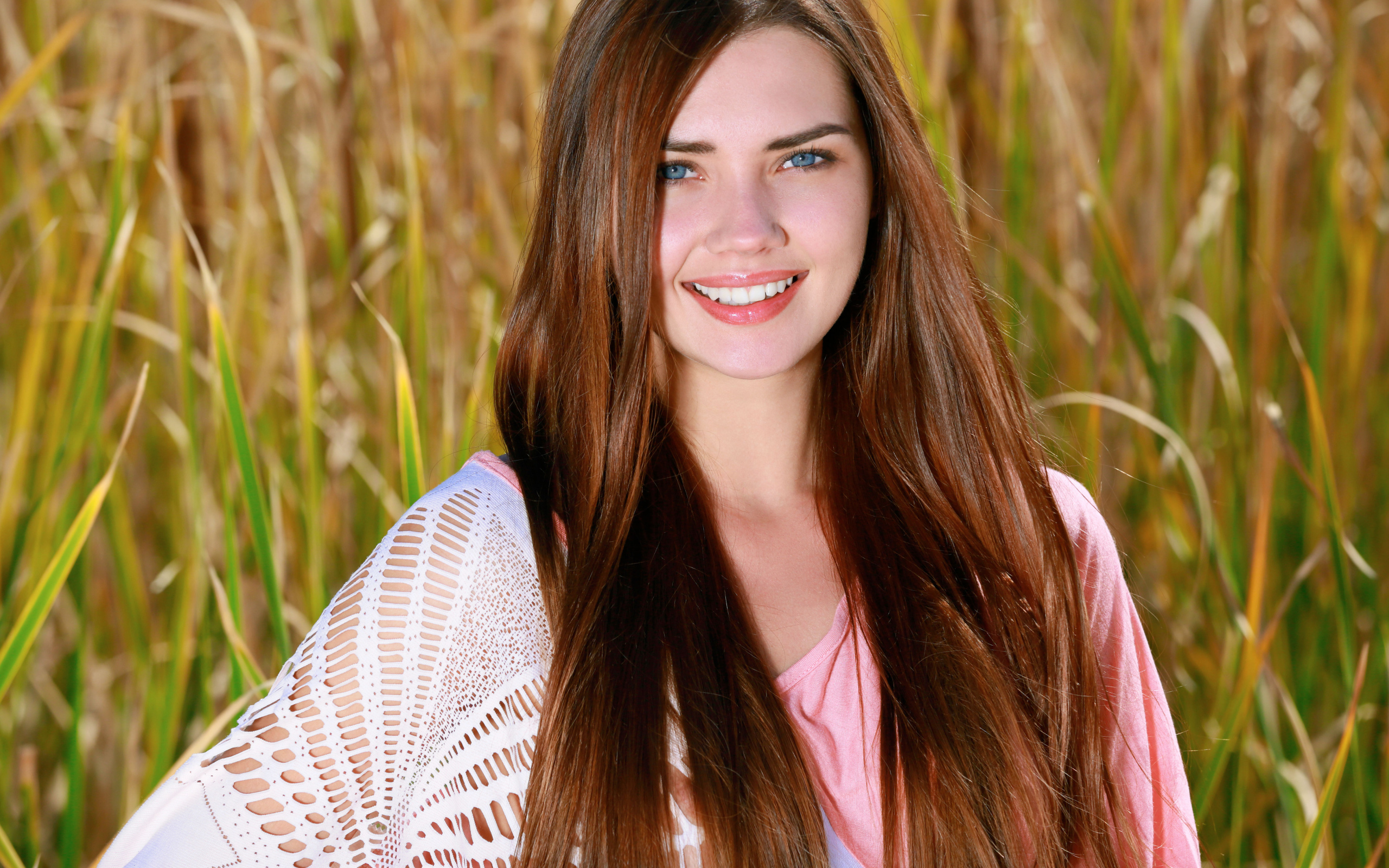 Улыбающаяся голубоглазая шатенка на поле