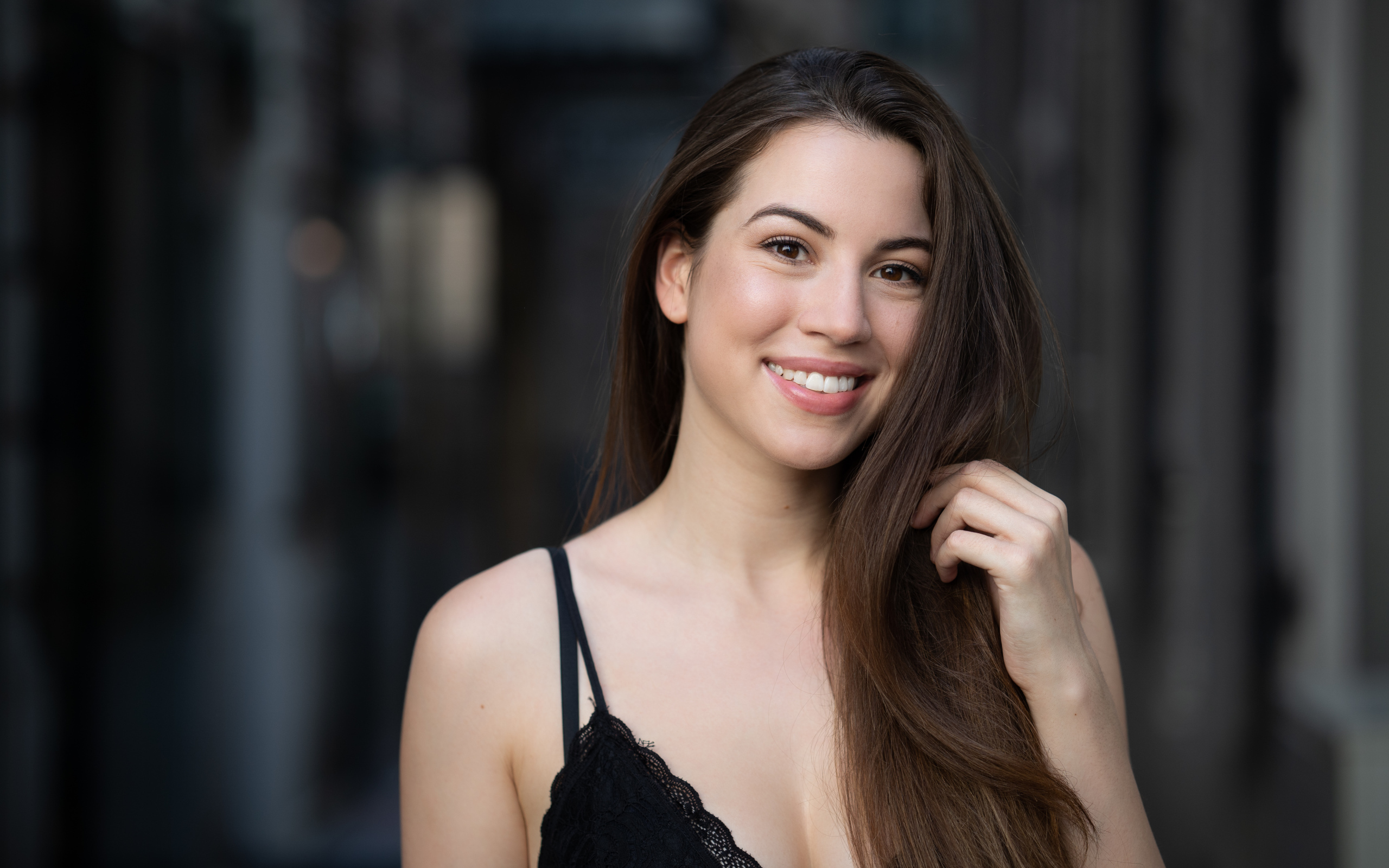 Улыбающаяся девушка держит длинные волосы