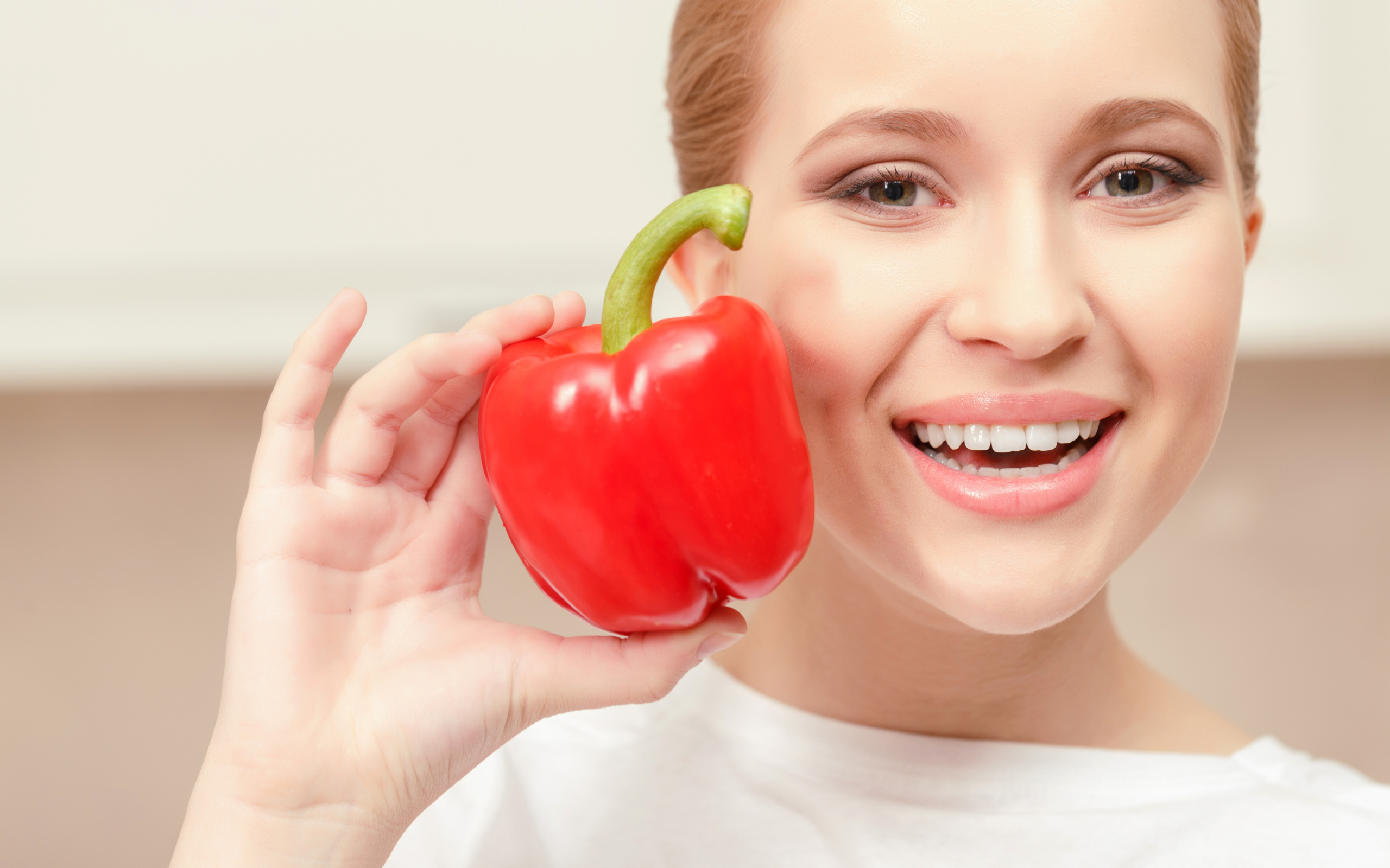 Улыбающаяся девушка с красным сладким перцем в руке